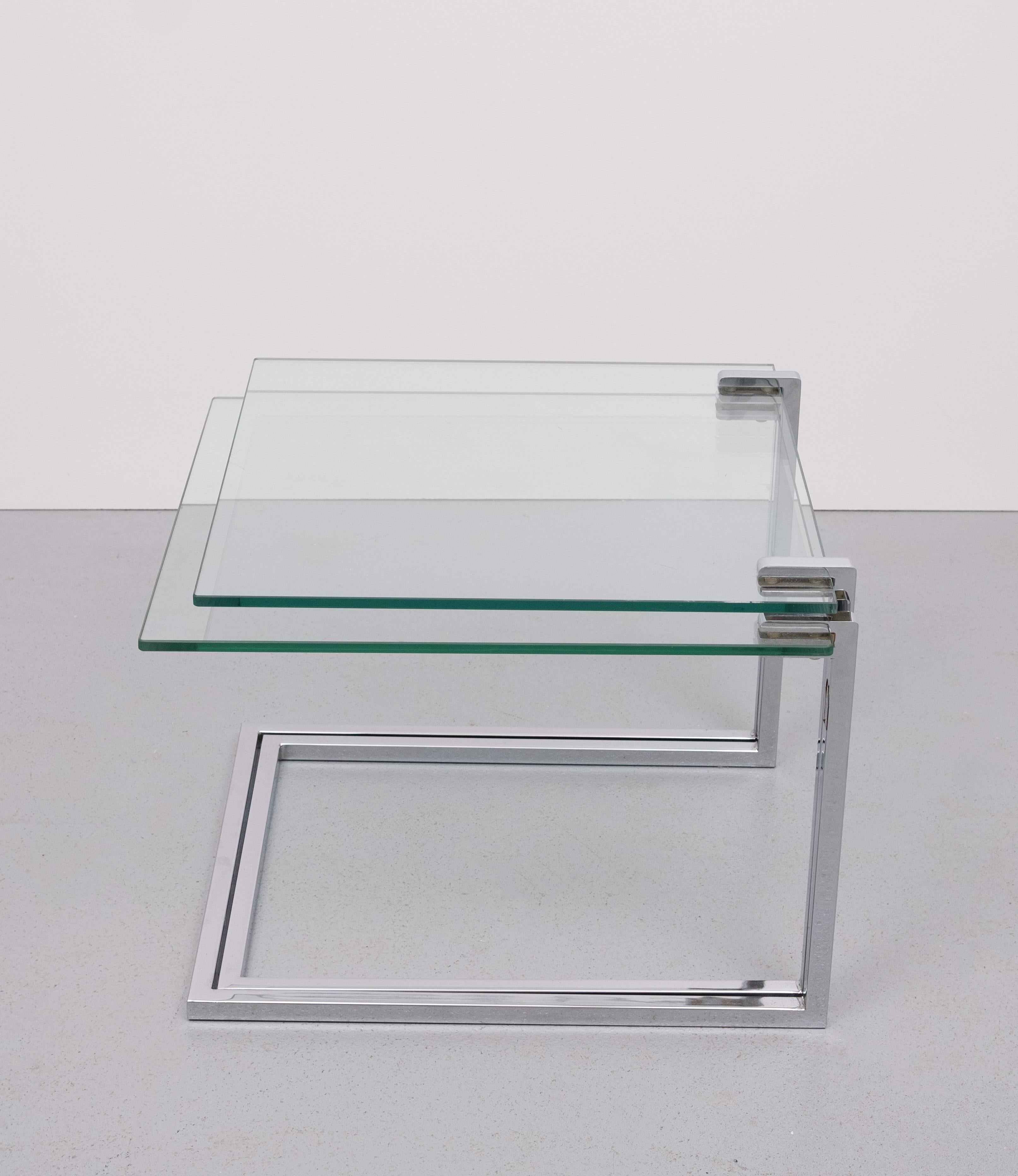 Ensemble de deux très belles tables gigognes , Chrome sur acier  base carrée .
 livré avec un plateau en verre épais.  . ensemble de bonne qualité .
Signé par Ronald Schmitt  Allemagne, années 1970 