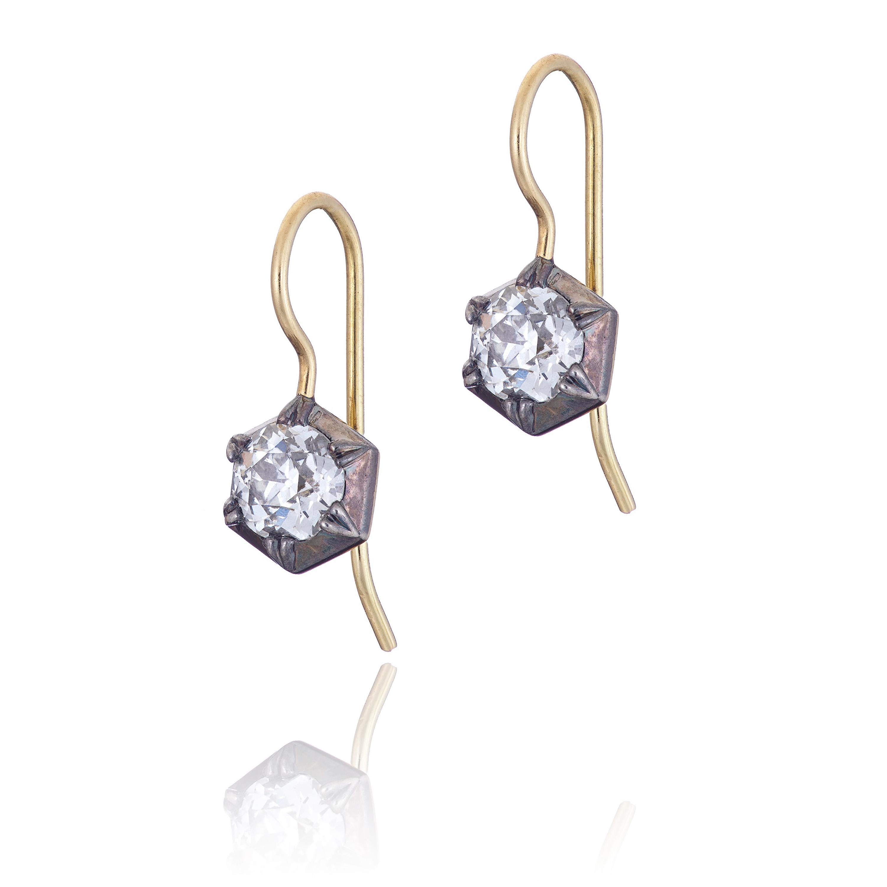 A one off pair of diamond earrings created using two matching old mine cut diamonds (1.28ct F VS). The Georgian cut down style highlights these unique diamonds which are full of character due to being cut totally by hand without the use of modern