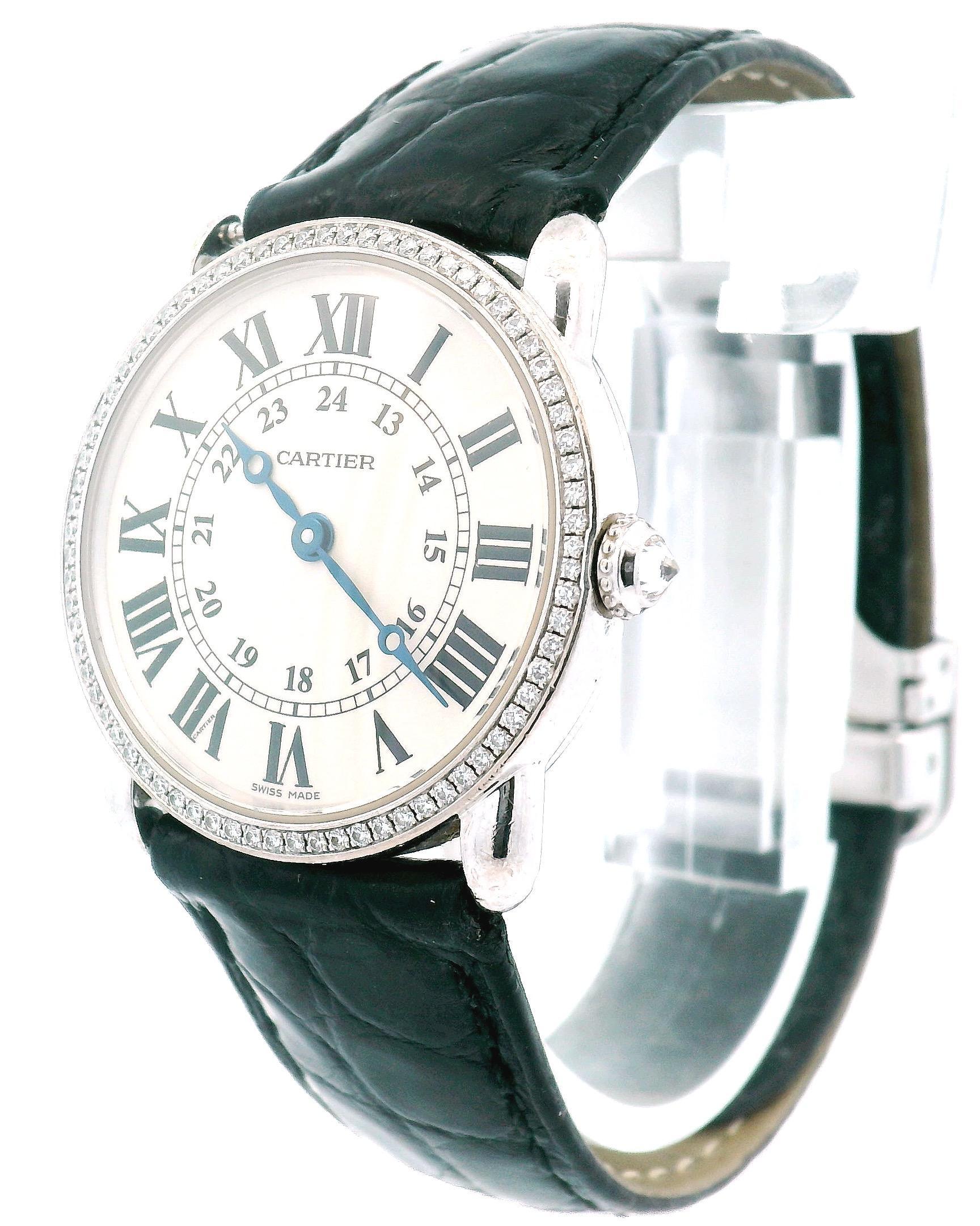 Ronde Louis Cartier Ladies Watch. 29mm 18K white gold case with factory diamond bezel. White dial with blue steel hands and Roman numeral hour markers.
24 hour and minute markers on the inner dial. Black leather with 18K white gold deployment buckle
