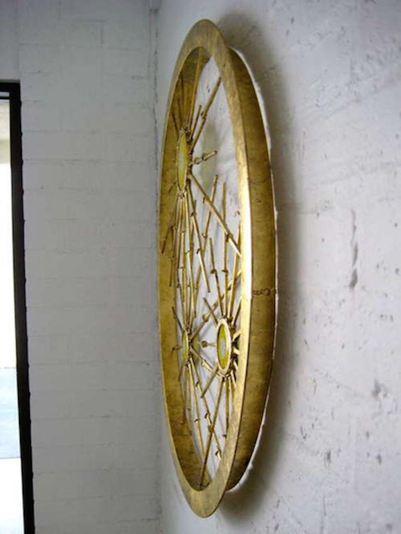 One of a series of rondo wall sculptures produced by California artist Del Williams, 2013. Hand-made glass and steel star bursts are layered and incorporated into a circular metal frame in an asymmetrical pattern. The entire sculpture has been gold