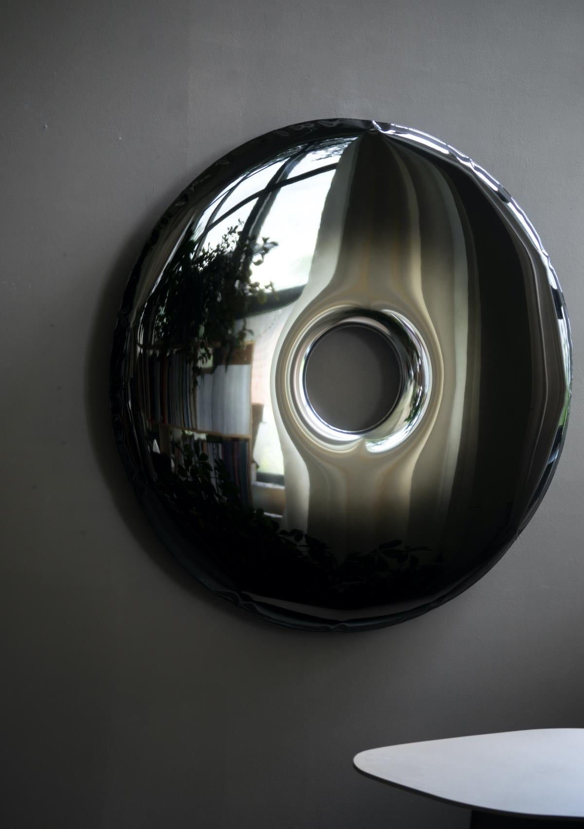 The Rondo mirror is made of stainless steel polished to high gloss. Its polished surface is perfectly reflecting the light and other objects placed in the same room or hall. Largescale convexities that appear on the surface of the mirror are