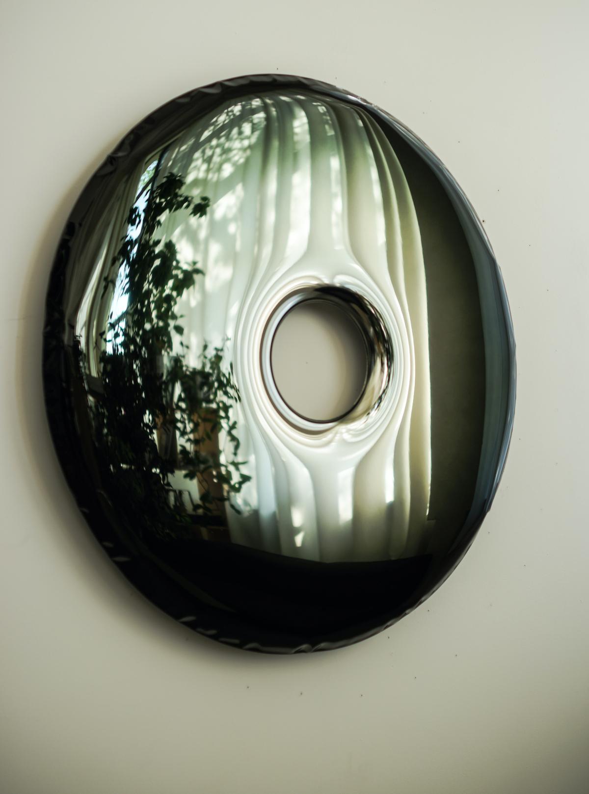 The Rondo mirror is made of stainless steel polished to high gloss. Its polished surface is perfectly reflecting the light and other objects placed in the same room or hall. Largescale convexities that appear on the surface of the mirror are