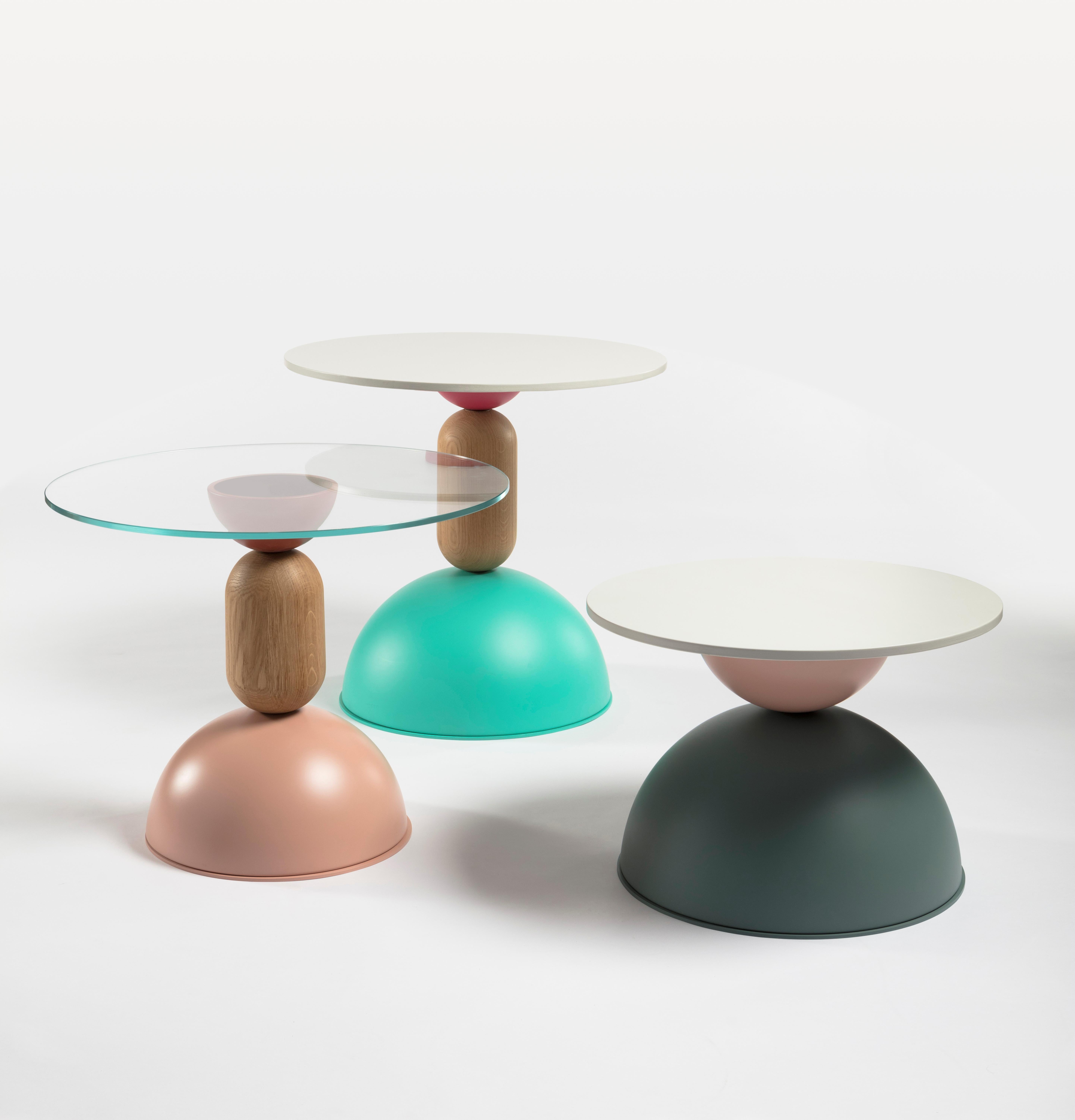 Una colección de mesitas de diferentes tamaños y alturas, compuestas por un versátil
Superposición de formas curvas de madera y metal coloreado. Como bailar
figuras, estos muebles, al mismo tiempo lúdicos y funcionales, realzan
espacios del hogar