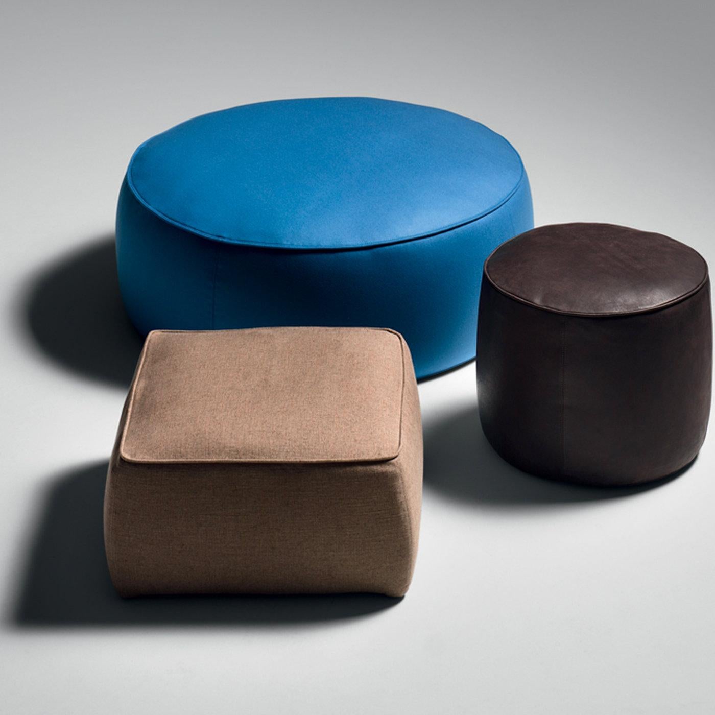 Ce pouf a un aspect minimal mis en valeur par des matériaux de haute qualité. Il présente une structure en bois de peuplier, rembourrée de polyuréthane haute résistance et multidensité et de mousse à mémoire de forme. Tapissé de cuir brun