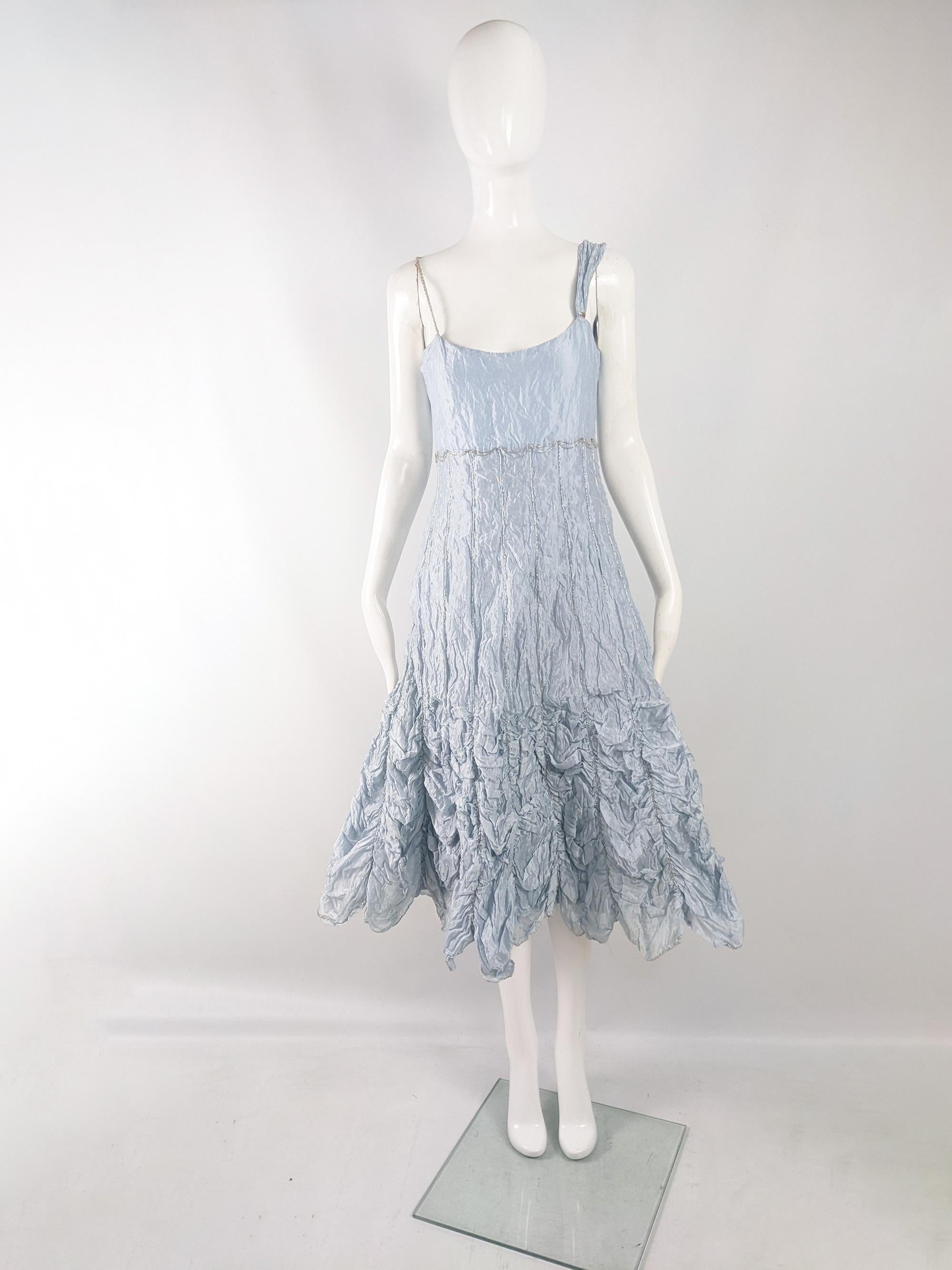An incredible vintage womens party dress from the early 2000s by luxury British fashion designer, Ronit Zilkha. In a crinkled pastel blue organza with one beaded spaghetti strap and one wider strap. The bottom has ruched fabric that flares out,