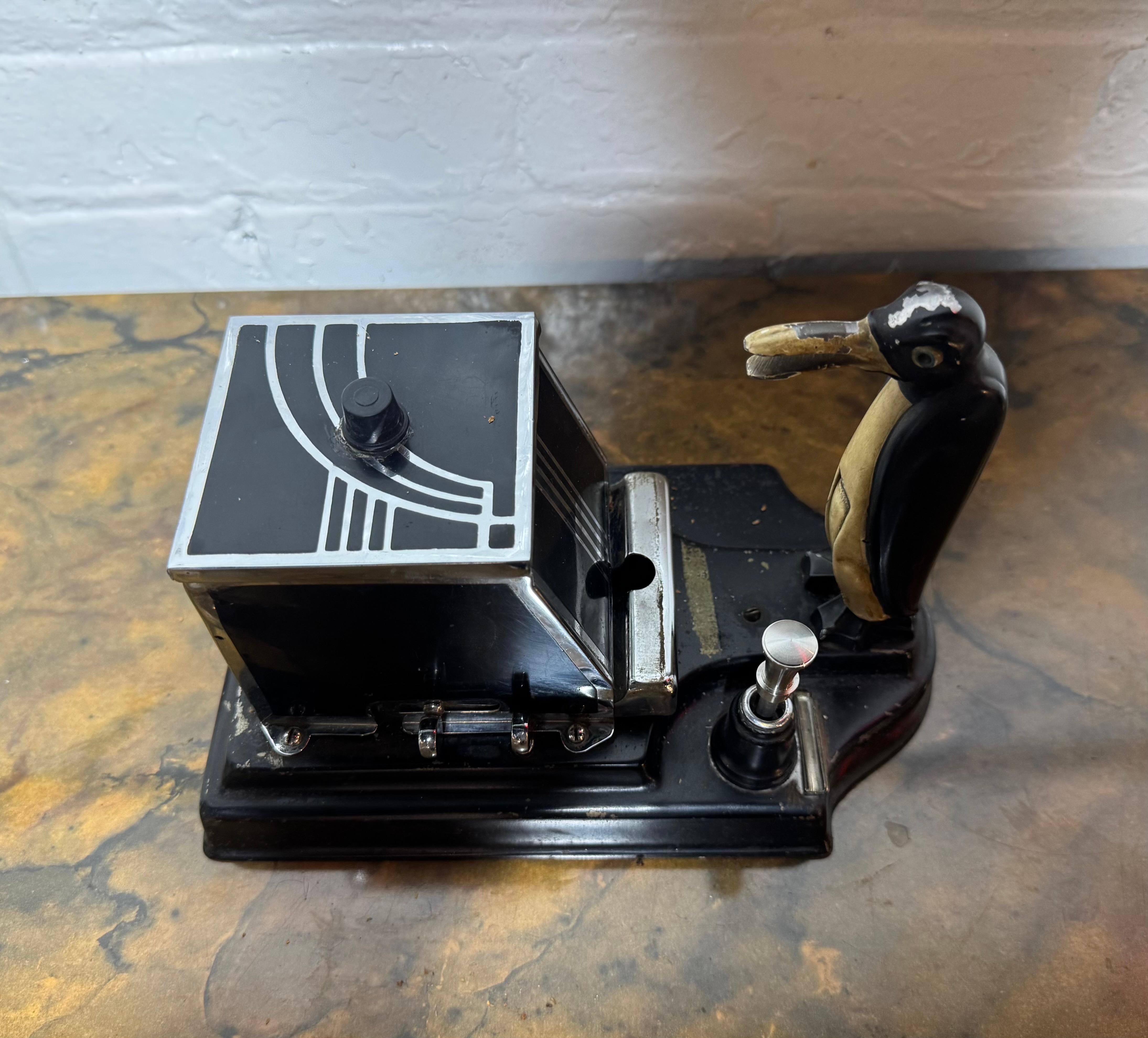 Boîte distributrice mécanique Art déco en forme de pingouin magique, conçue par Ronson.

Une belle, extrêmement rare et très décorative boîte de bureau à distributeur mécanique, créée dans la ville de Newark, New Jersey aux États-Unis par The Ronson