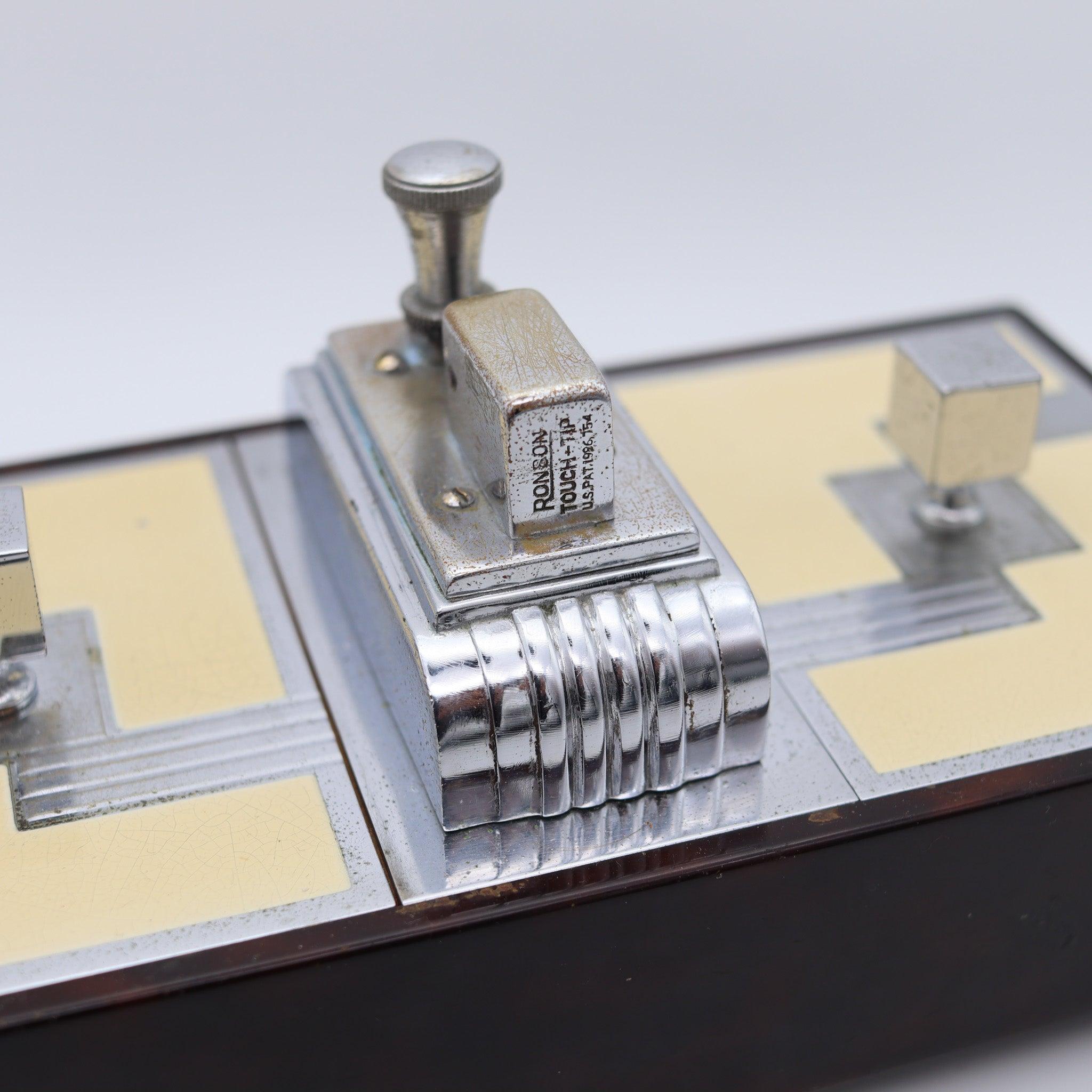 Caja de escritorio doble con encendedor diseñada por Ronson.

Una excepcional y bellísima caja de escritorio, creada en Nueva Jersey, Estados Unidos, por The Ronson Co. durante el periodo art déco, allá por 1935. Se trata de una rara caja doble con