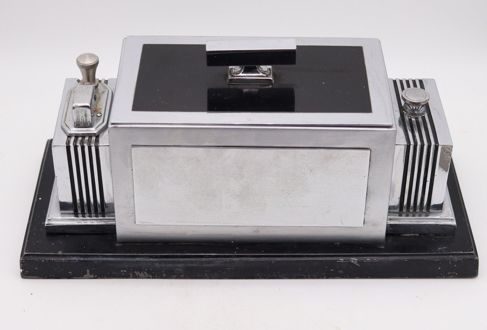 Ronson Art Deco-Kombination Humidor und Touch Tip Tischfeuerzeug.

Dieses Art-Déco-Raucherzubehör ist eine Kombination aus Humidor-Box und Touch-Tip-Feuerzeug von Ronson Lighter Co. aus den 1930er Jahren. Er hat einen maskulinen, architektonischen
