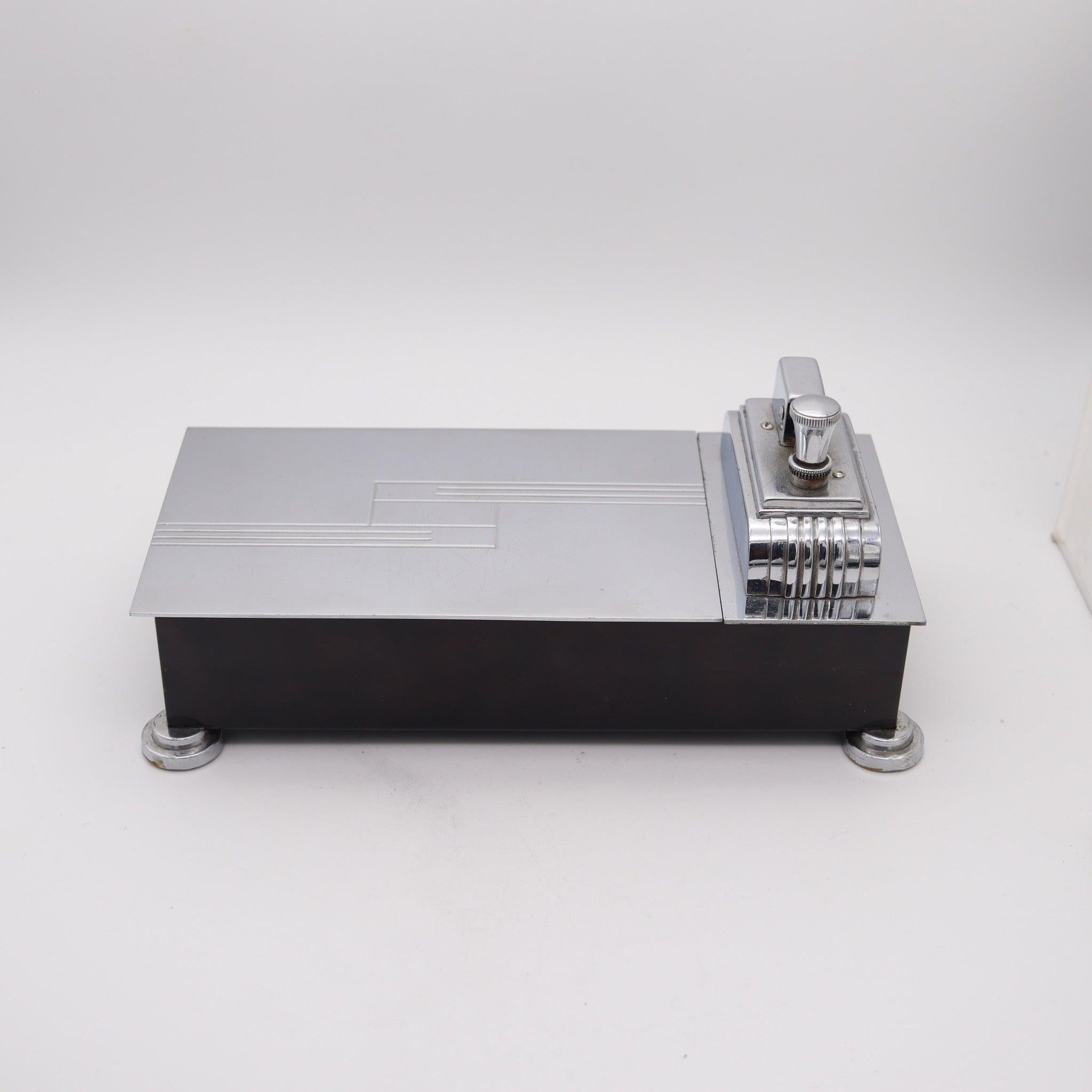 Scatola humidor per sigarette da tavolo con accendino disegnata da Ronson.

Si tratta di un'incredibile scatola per sigarette da tavolo & accendino a sfioramento, creata in New Jersey negli Stati Uniti da The Ronson Lighter Co. durante il periodo
