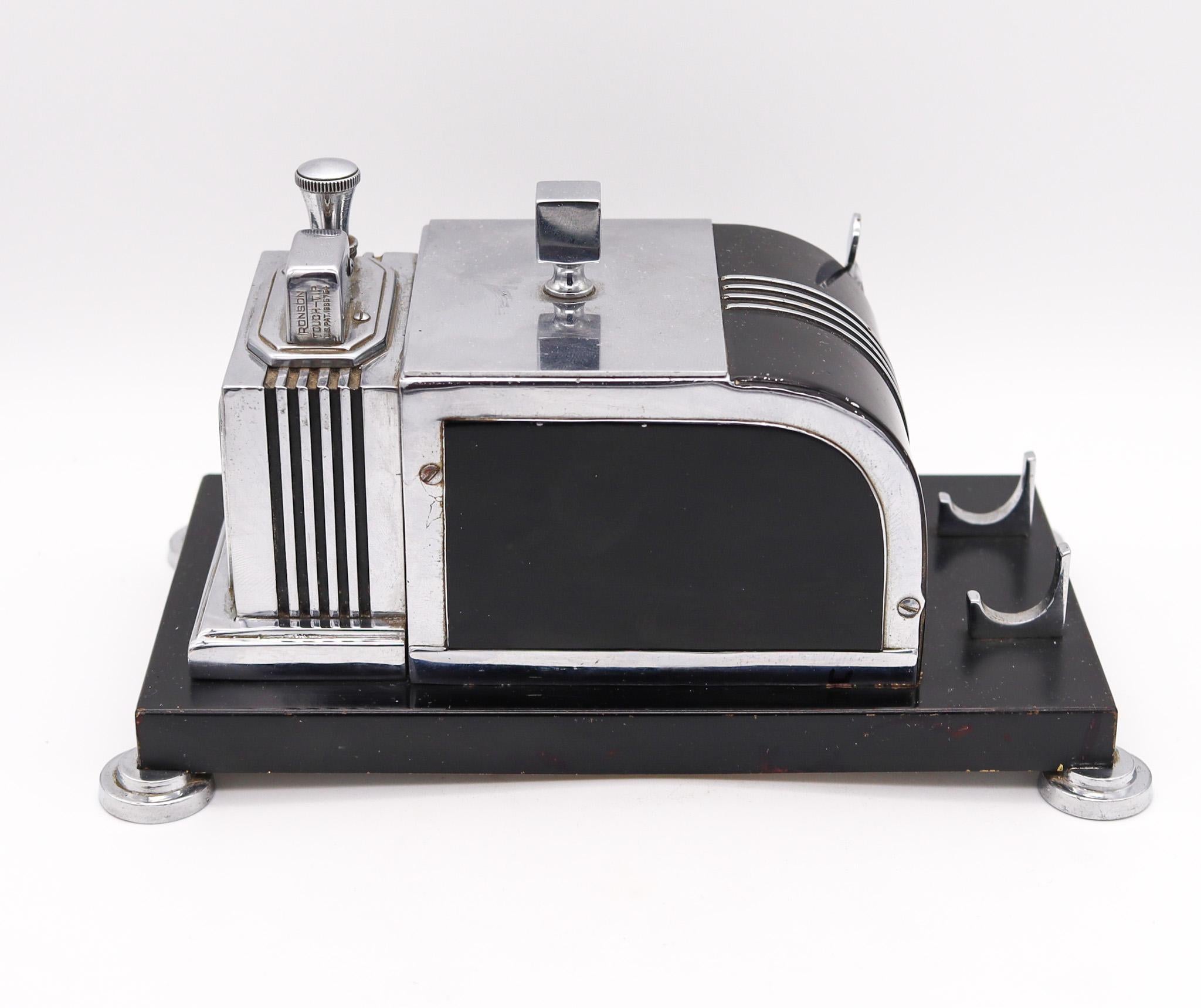 Art deco mechanical dispenser box with lighter made by Ronson.

An exceptional and very decorative mechanical desk box, created in the city of Newark, New Jersey United States by The Ronson Metal Works Co. during the art deco period, back in the