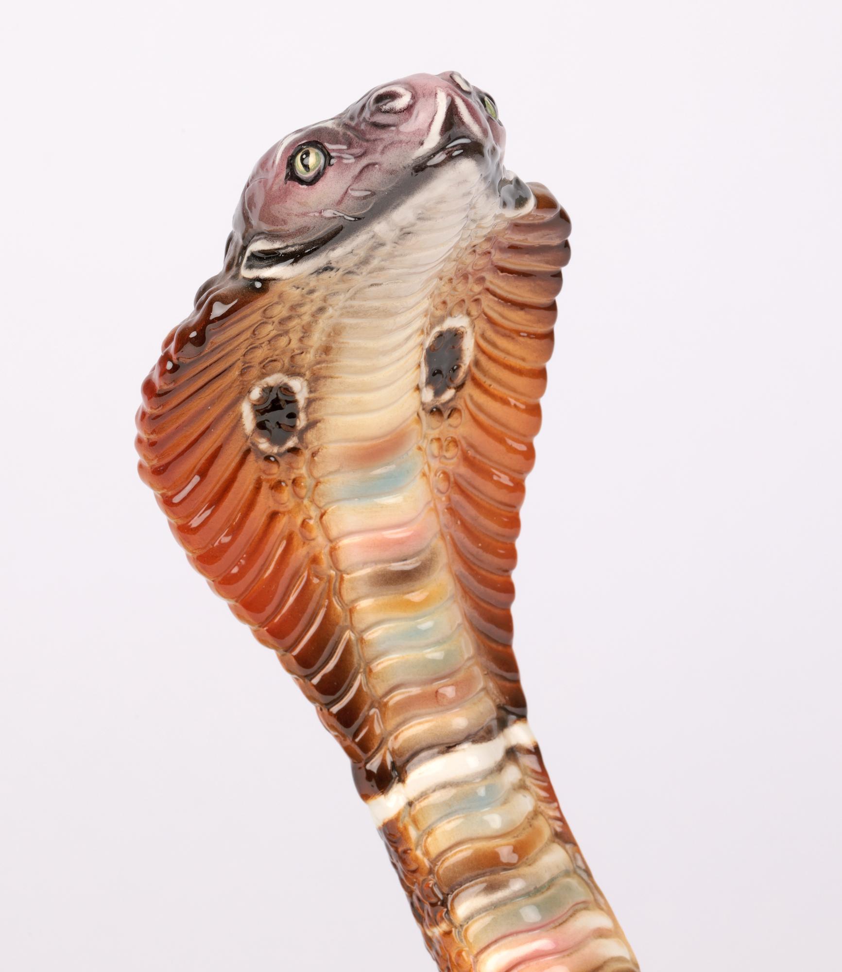 A large and exceptional midcentury Ronzan Italian ceramic cobra snake in the style of Lenci and dating from around 1950. The large hollow made snake sits coiled with its head raised in a defensive manner with the tip of its tail also raised. The