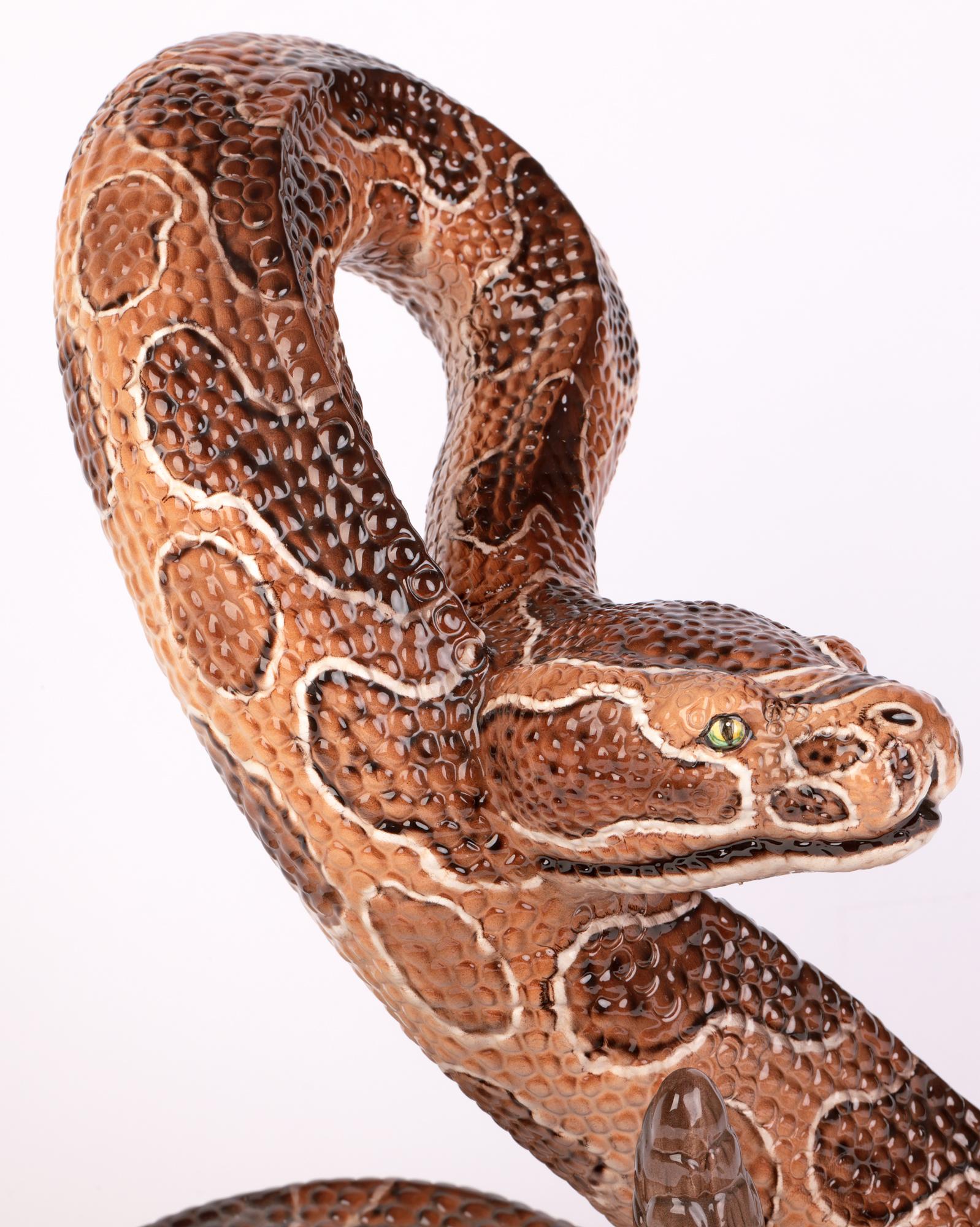 Un grand et exceptionnel serpent à hochet en céramique italienne Ronzan du milieu du siècle dans le style de Lenci et datant d'environ 1950. Le grand serpent creux est enroulé, la tête levée de manière défensive et le bout de sa queue, le hochet,