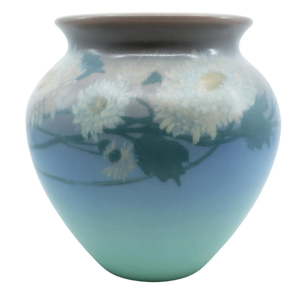 Offering this gorgeous hand-painted vellum Rookwood pottery vase featuring a detailed vine and bloom design. This vase is hand-painted with beautiful hues of blue, mauve, green and peach. Vase is artist signed 