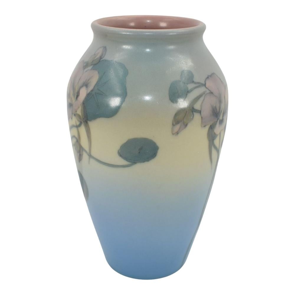 Wir bieten diese wunderschöne handbemalte Vase aus Rookwood-Keramik mit einem detaillierten Kapuzinerkresse-Blumenmuster an. Diese Vase ist mit schönen blauen, gelben und grünen Farbtönen sowie rosa Blumen handbemalt. Die Vase ist signiert mit 