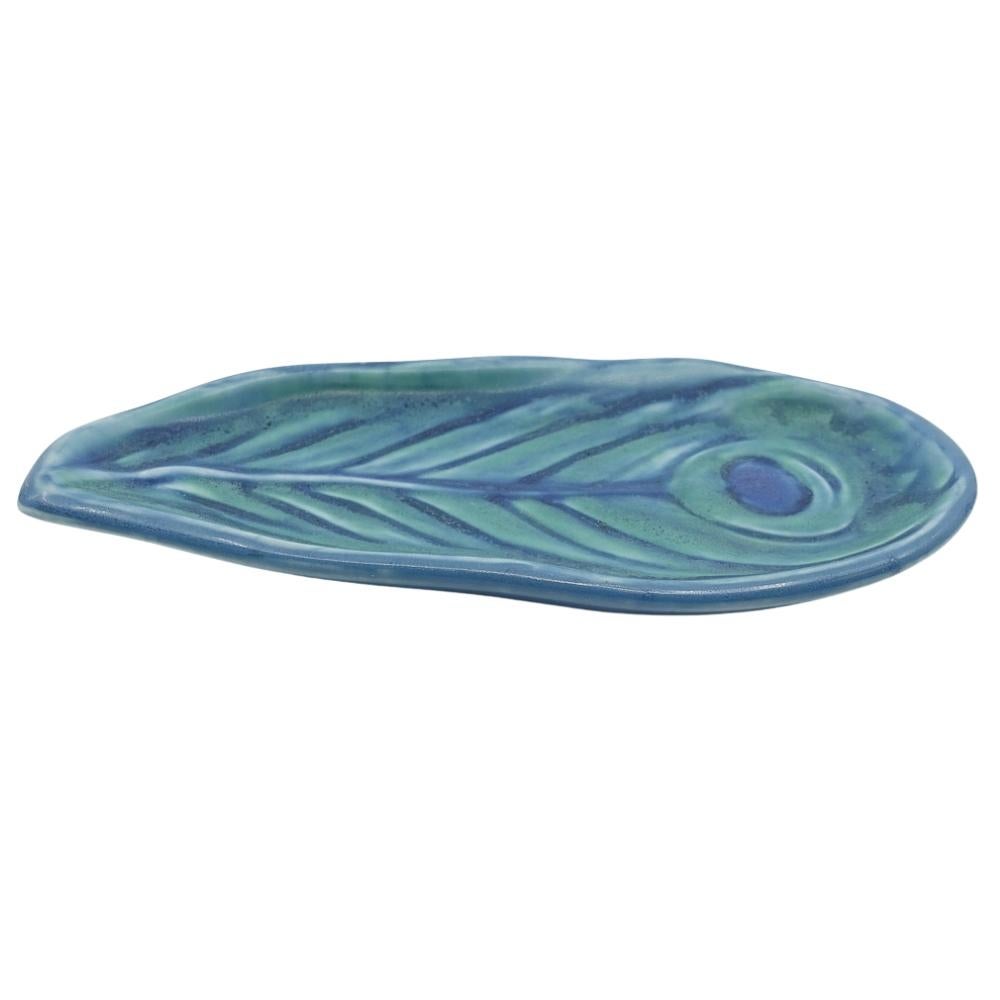 Offering this gorgeous hand-painted vellum Rookwood pottery tray featuring a detailed multi-colored peacock feather design. This tray is hand-painted with beautiful hues of blue, green and purple. Tray is a known deign by famous Rookwood artist