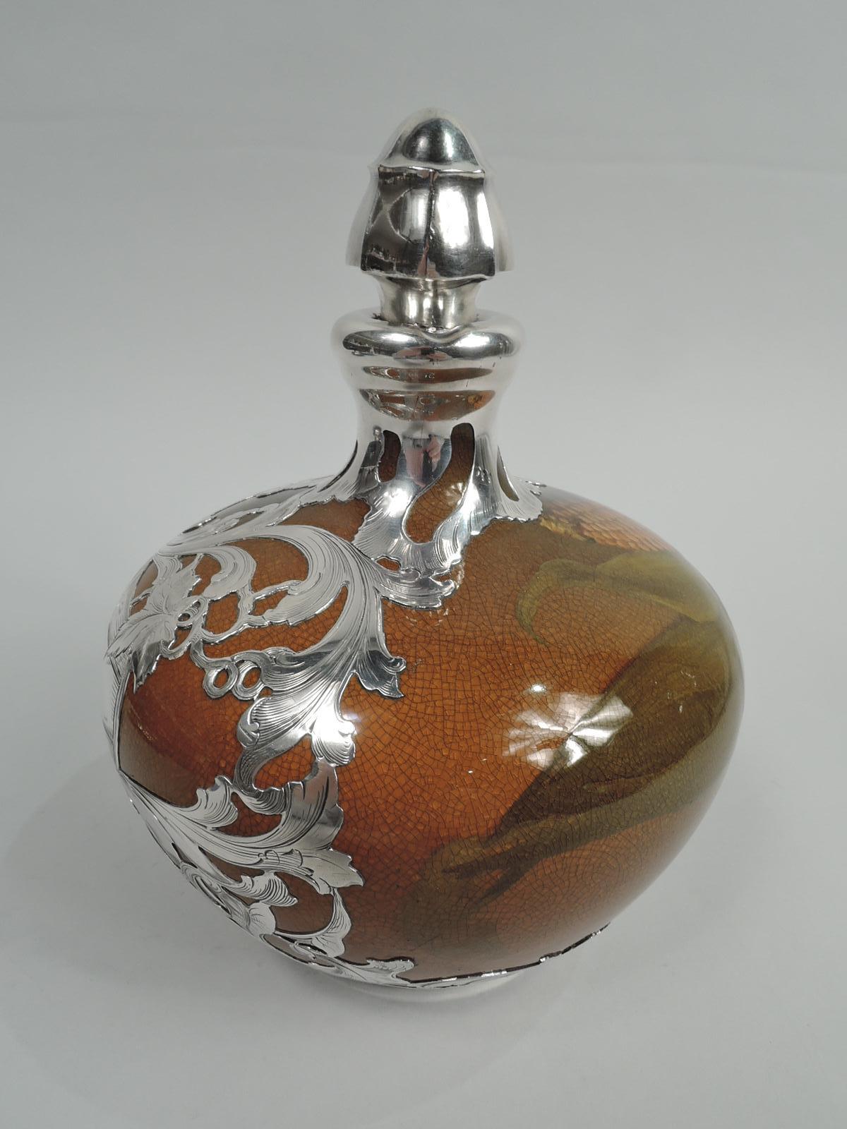 Art Nouveau Craftsman glazed jug decanter with engraved silver overlay. Made by Rookwood Pottery in Cincinnati in 1896. Wide ovoid body with short neck and ring handle in silver collar. Shaped stopper with cork plug. Corn cob with peeled-back husk