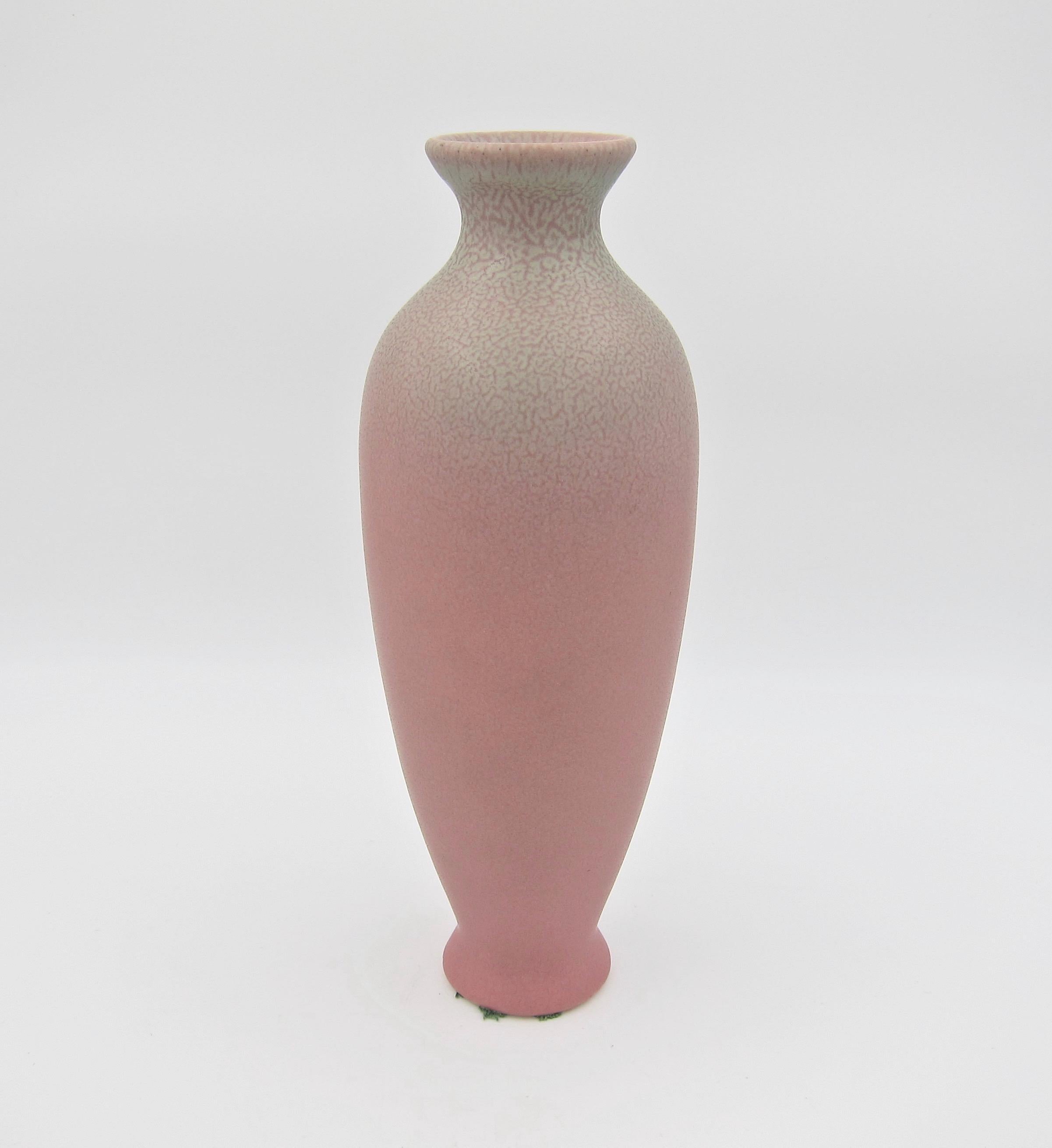A Rookwood Pottery production vase made during the Arts & Crafts period in 1925. The American art pottery vase is of baluster form with an artistic matte glaze of a velvety dusty rose-pink with pale green accents around the mouth, rim, and