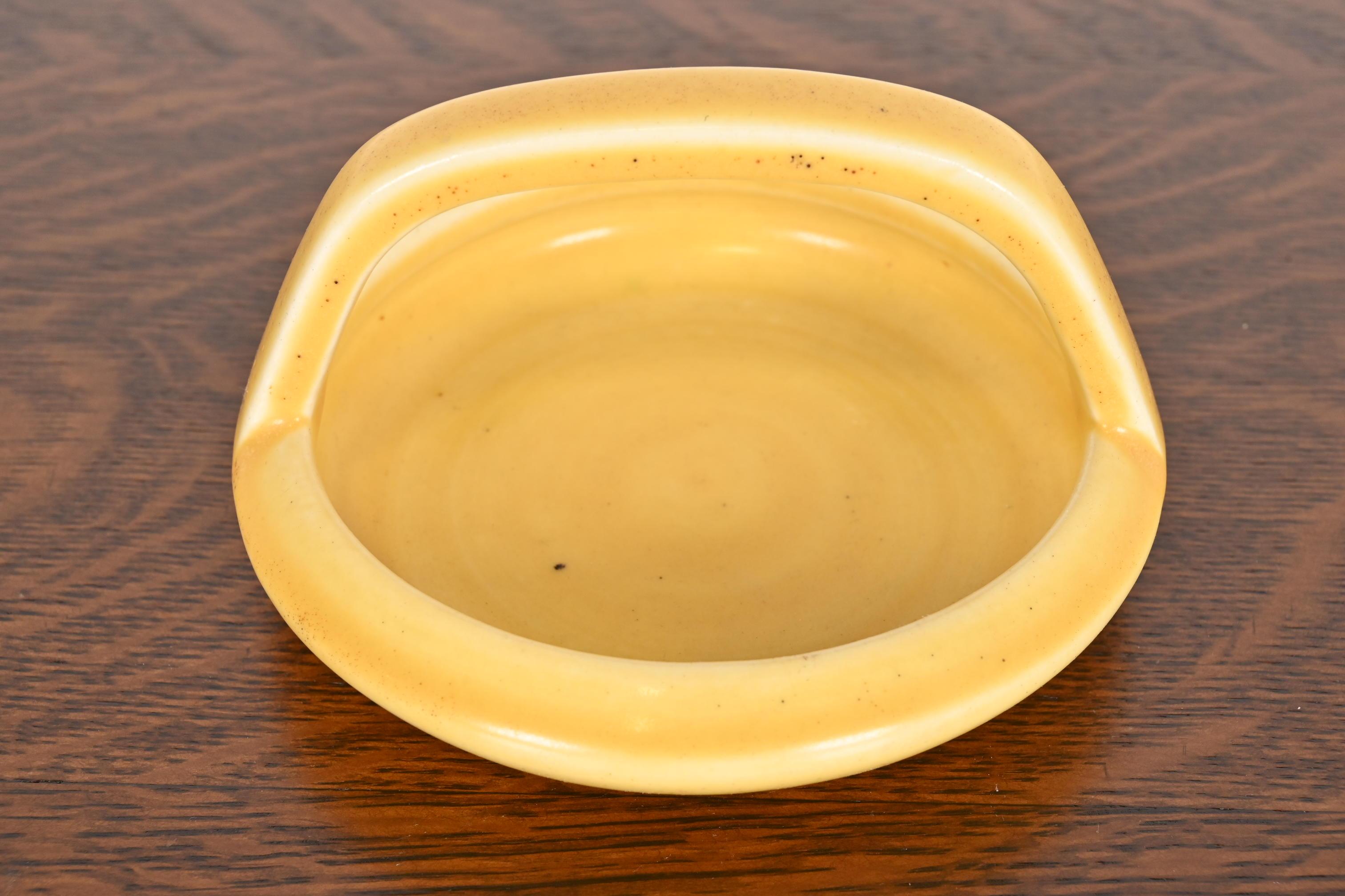 A gorgeous Arts & Crafts period glazed ceramic art pottery handled bowl, catchall, or ashtray

By Rookwood Pottery

USA, 1922

Glazed ceramic, in a beautiful yellow color.

Measures: 5.63