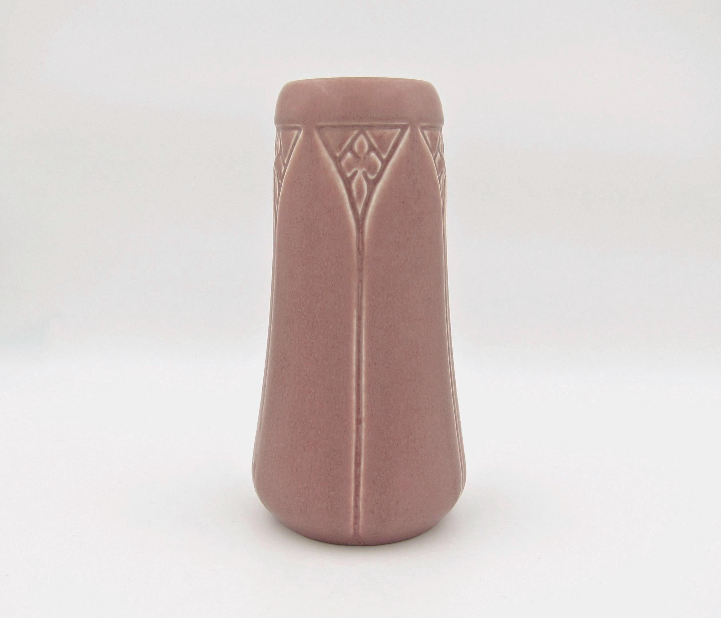 A Rookwood Pottery production vase made during the Arts & Crafts period in 1921. This elegant American vase is decorated with molded lines that meet in pointed arches under the rim; these arches alternate with stylized fleur-de-lys motifs. The
