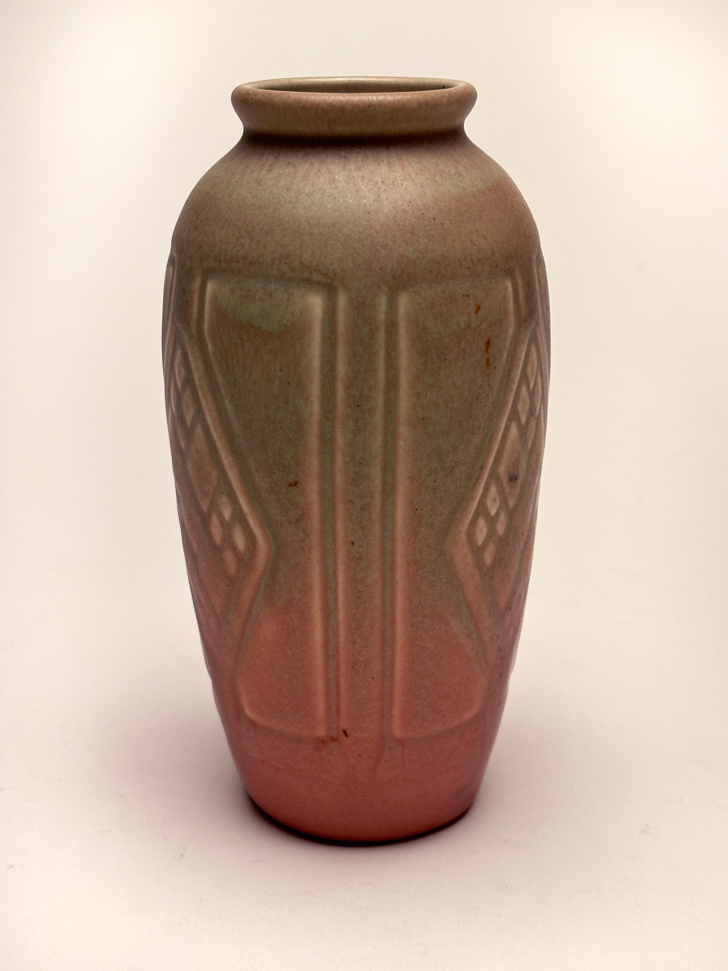 This beautiful example of an Arts and Crafts era piece showcases Rookwood's extraordinary craftsmanship and creative use of glazes. Made in 1921, it was a production piece, utilizing matte rose pink glaze combined with a soft moss green glaze that