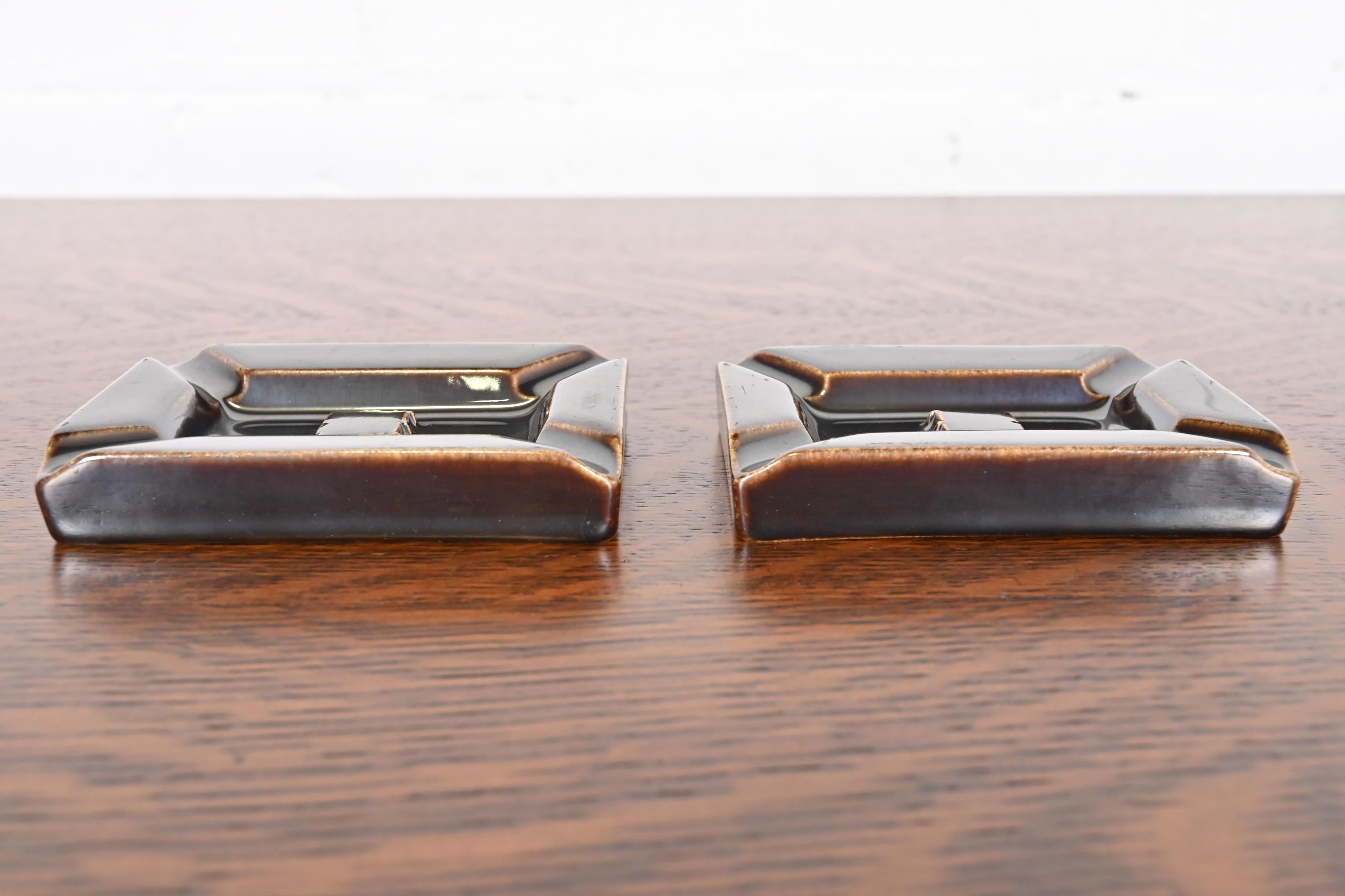 A gorgeous pair of Arts & Crafts or Mid-Century Modern glazed art pottery ashtrays or catchalls

By Rookwood Pottery

USA, 1954

Glazed ceramic in a handsome deep brown color.

Each measures: 4.25