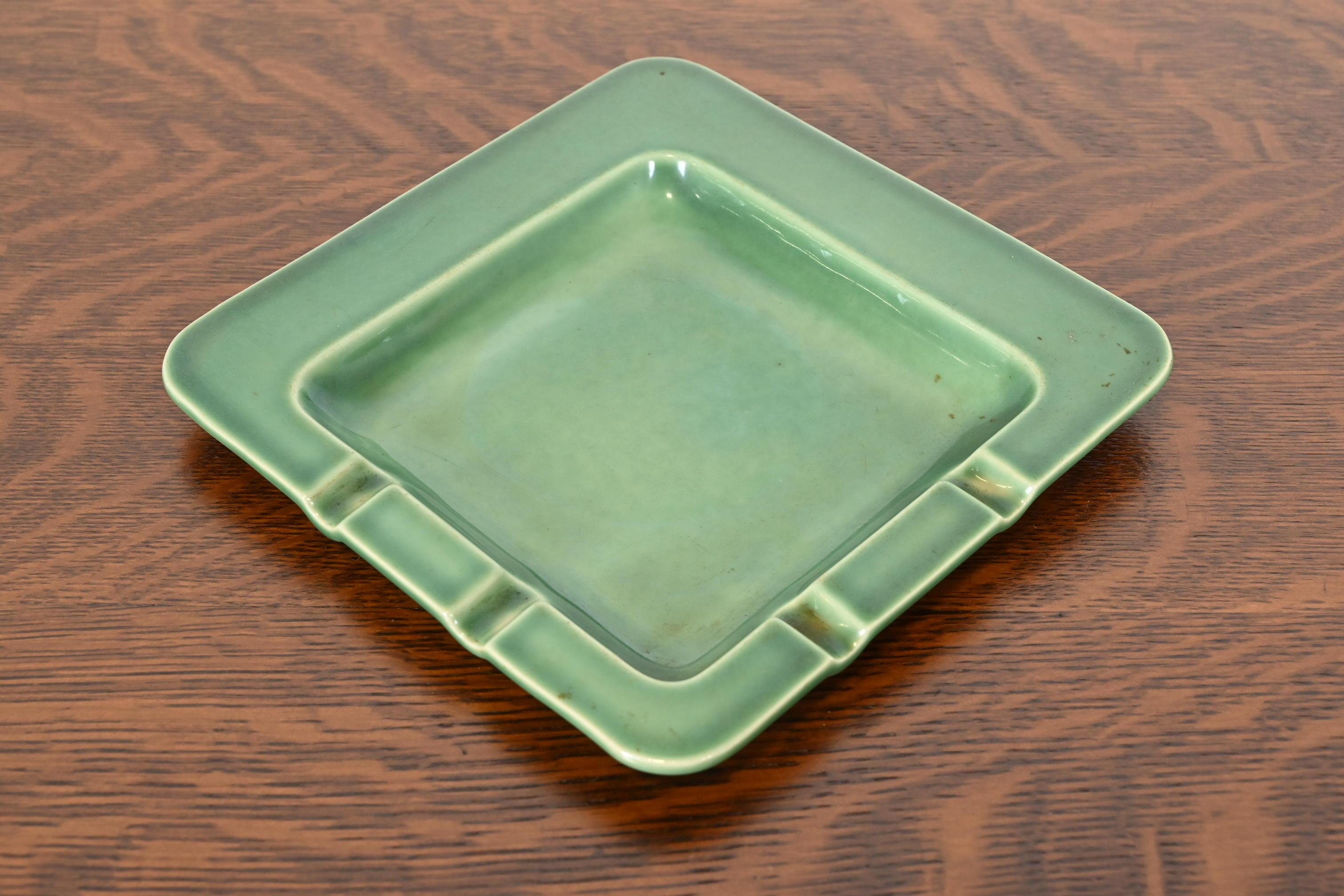 A gorgeous Arts & Crafts or Mid-Century Modern glazed art pottery ashtray or catchall

By Rookwood Pottery

USA, 1955

Glazed ceramic in a handsome green color.

Measures: 8.75