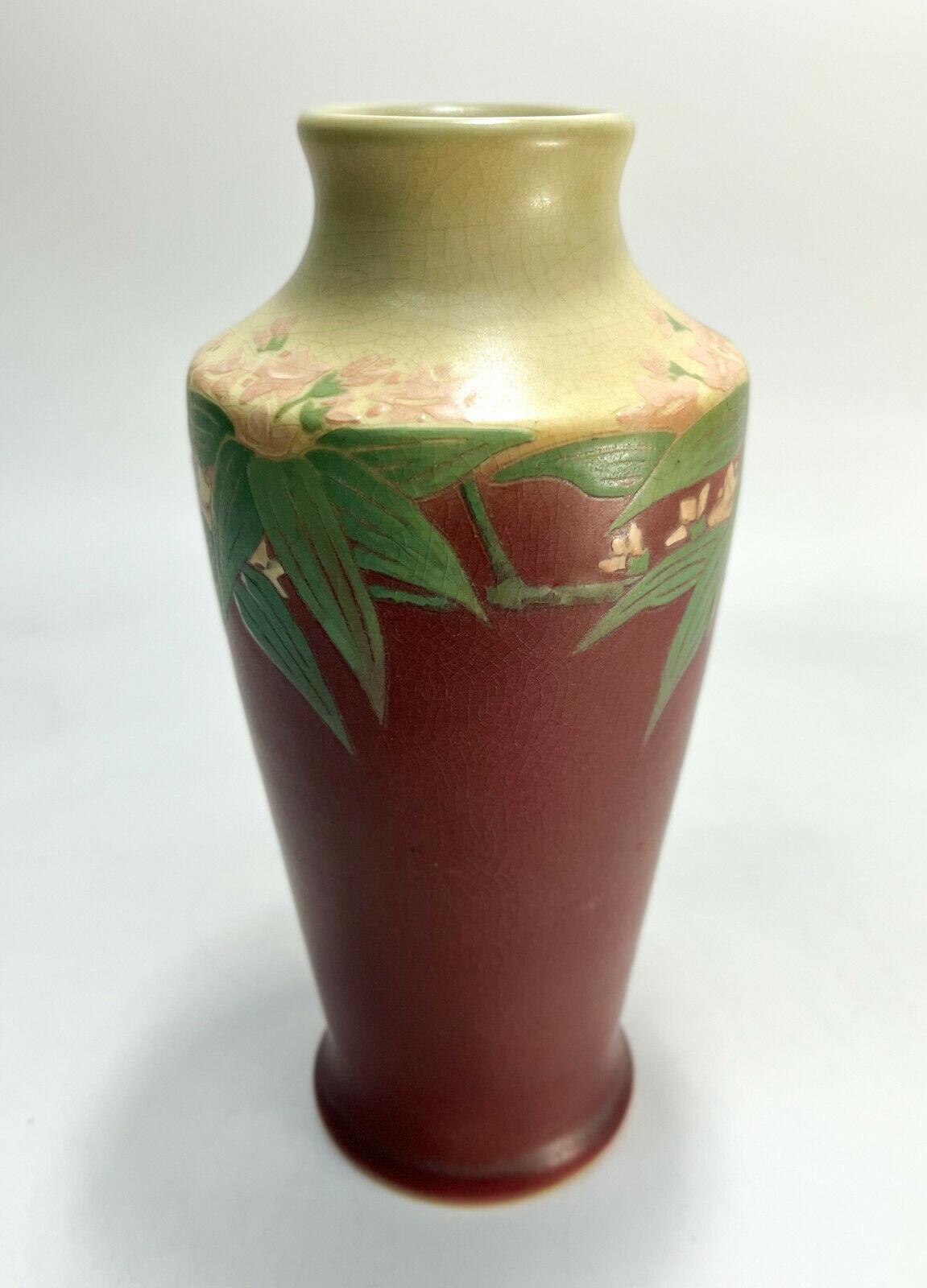 Rookwood Pottery Vellum Porcelain Vase #1920 by Lorinda Epply, 1912

A cream and berry red ground with florals to the circular band. Rookwood mark to the underside with maker mark initals for Lorinda Epply.

Additional information:  
Production