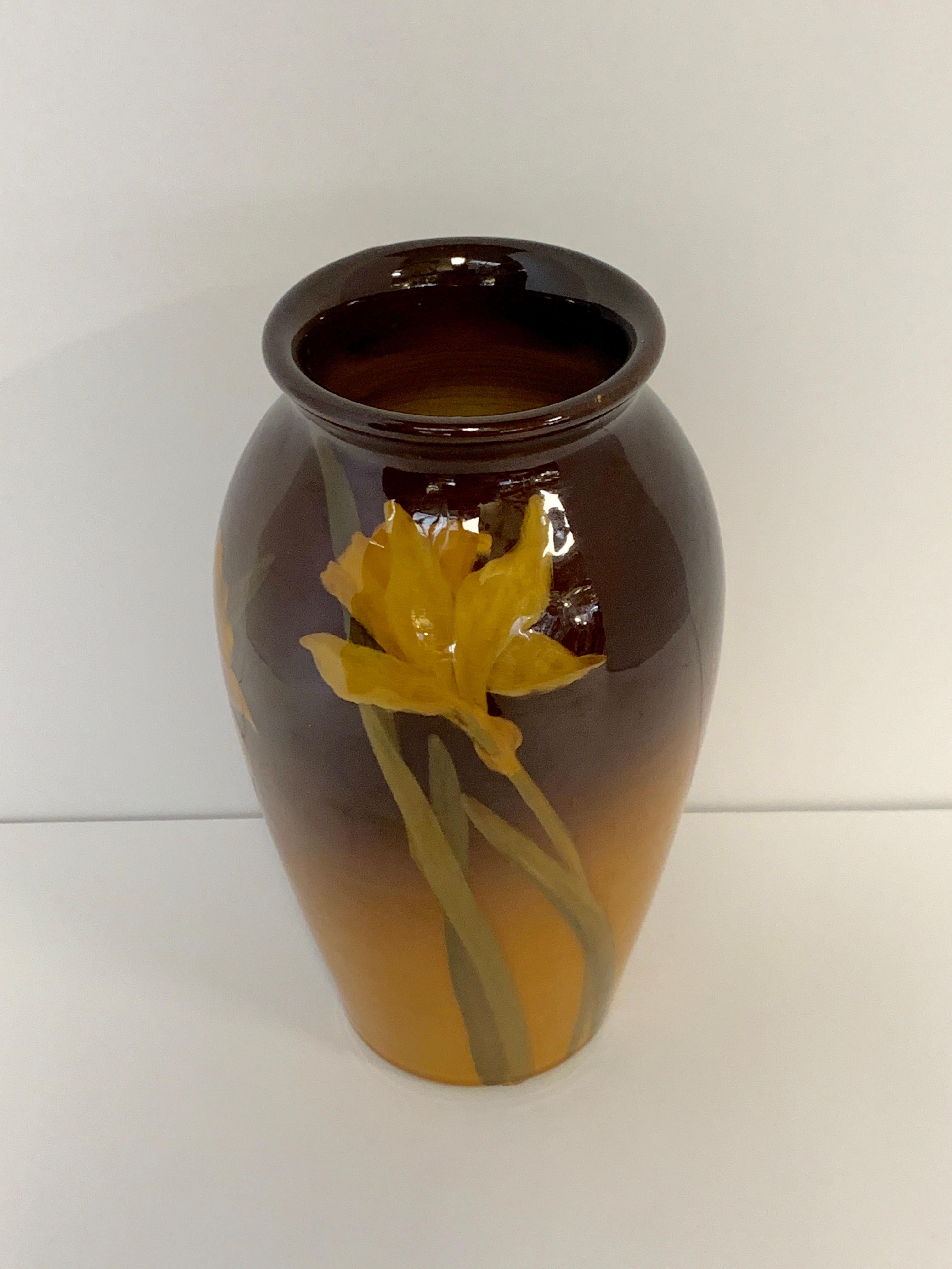 A beautiful early 20th century vase decorated by Clara Lindeman. it is marked on the base with her initial C.C.l. and the Rookwood logo. It also features a sticker with a retailer name Davis Collamore & Co. from NYC. The vase appears in good age