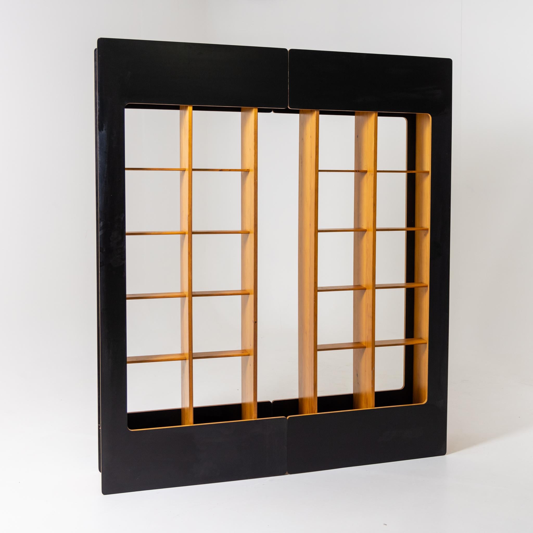 Large shelf with black framing and square compartment division. The two halves can be joined in different ways.