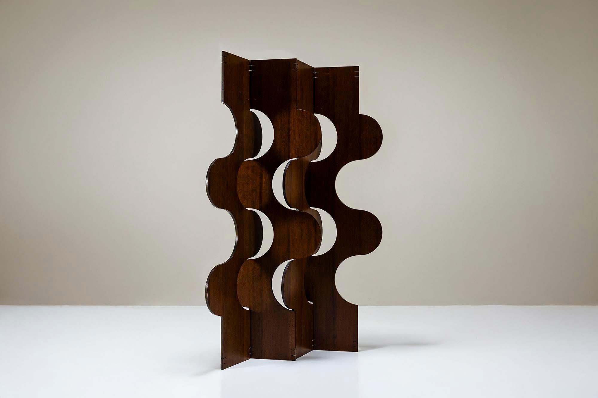 This room divider brings the iconic seventies aesthetic into modern interiors. With its sculptural form and rich teak veneer, it transforms a space while remaining practical and easy to move.

Design
Four panels of layered wood form the structure,