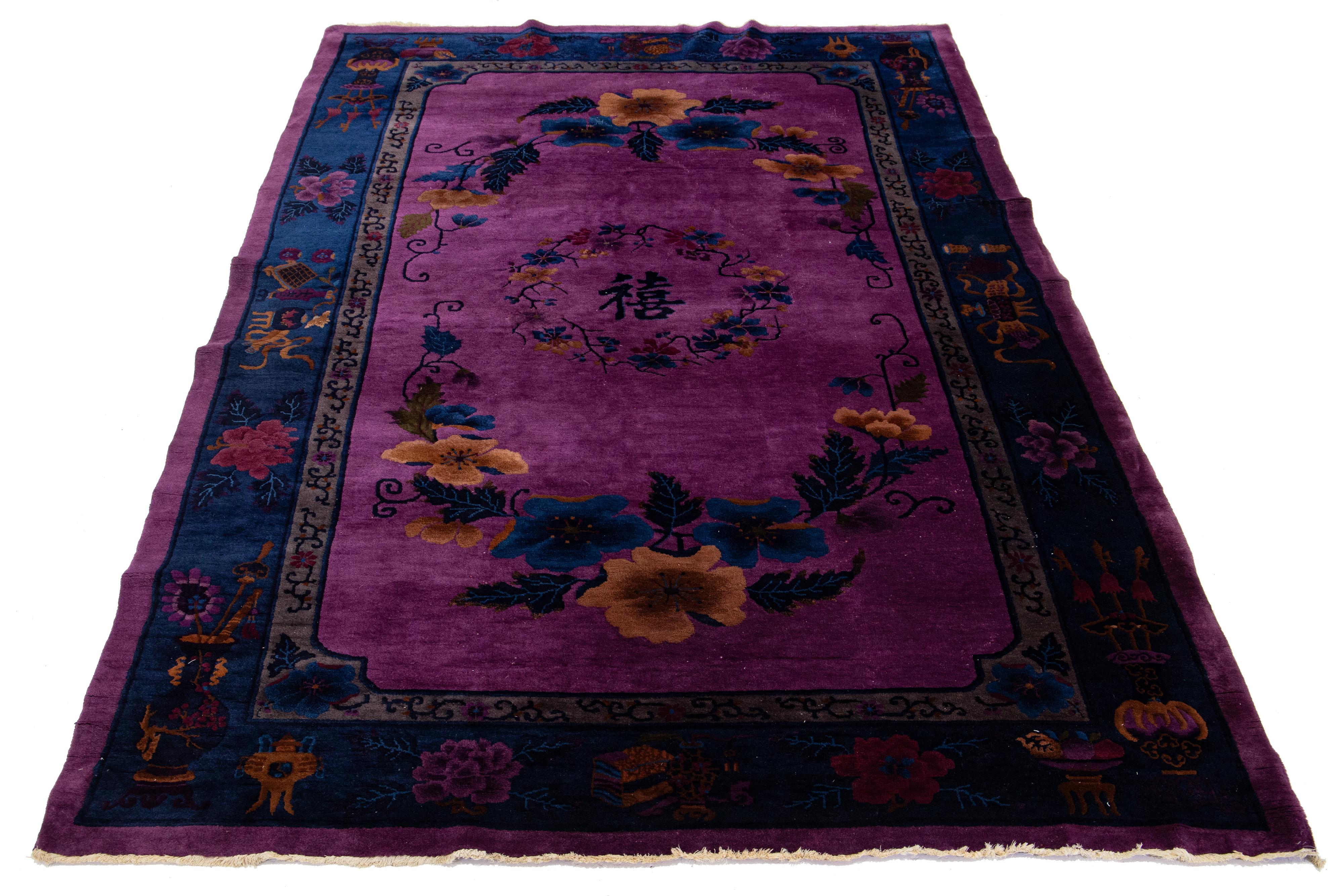 This stunning hand-knotted wool rug features a purple field with a navy blue border and multicolored accents, all arranged in a beautiful Chinese floral pattern.

This rug measures 6'11