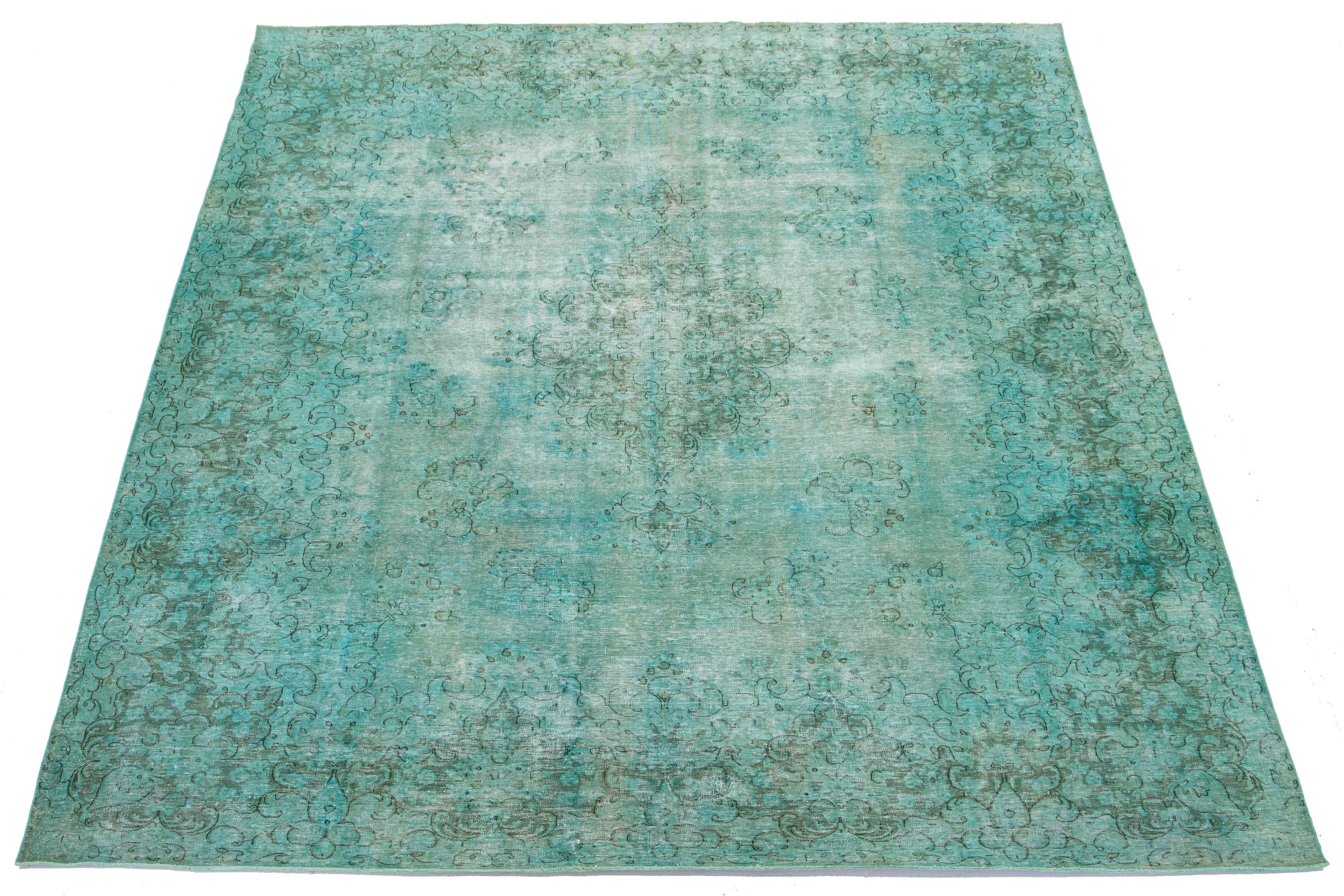 This is an antique hand-knotted wool Persian rug with a light green field. It features a medallion floral design with gray accents.

This rug measures 9'11'' x 13'2