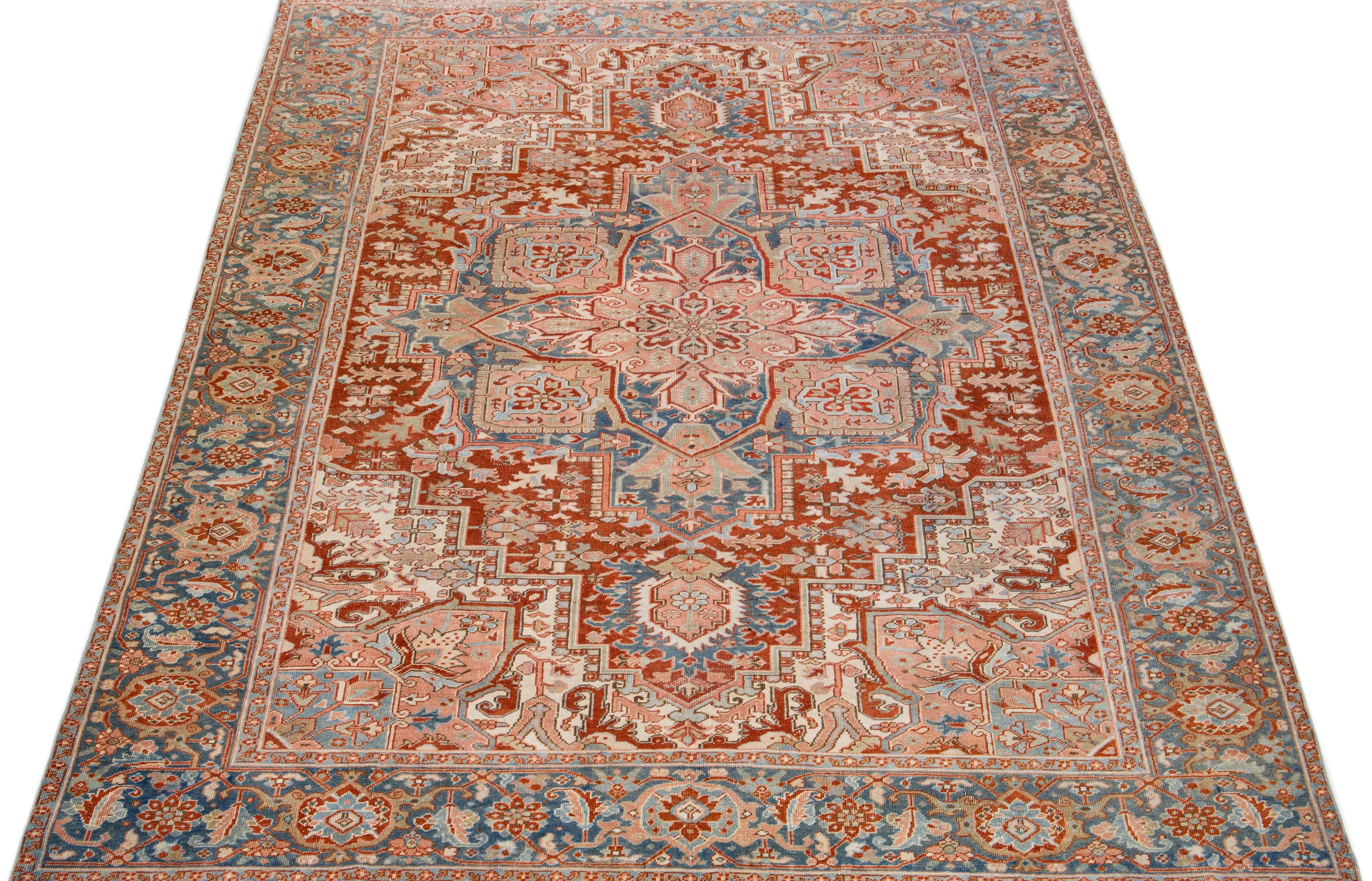 Beautiful antique Heriz hand-knotted wool rug with a beige color field. This Persian rug has a blue frame and pink accents in a gorgeous all-over geometric floral design.

This rug measures: 8'3