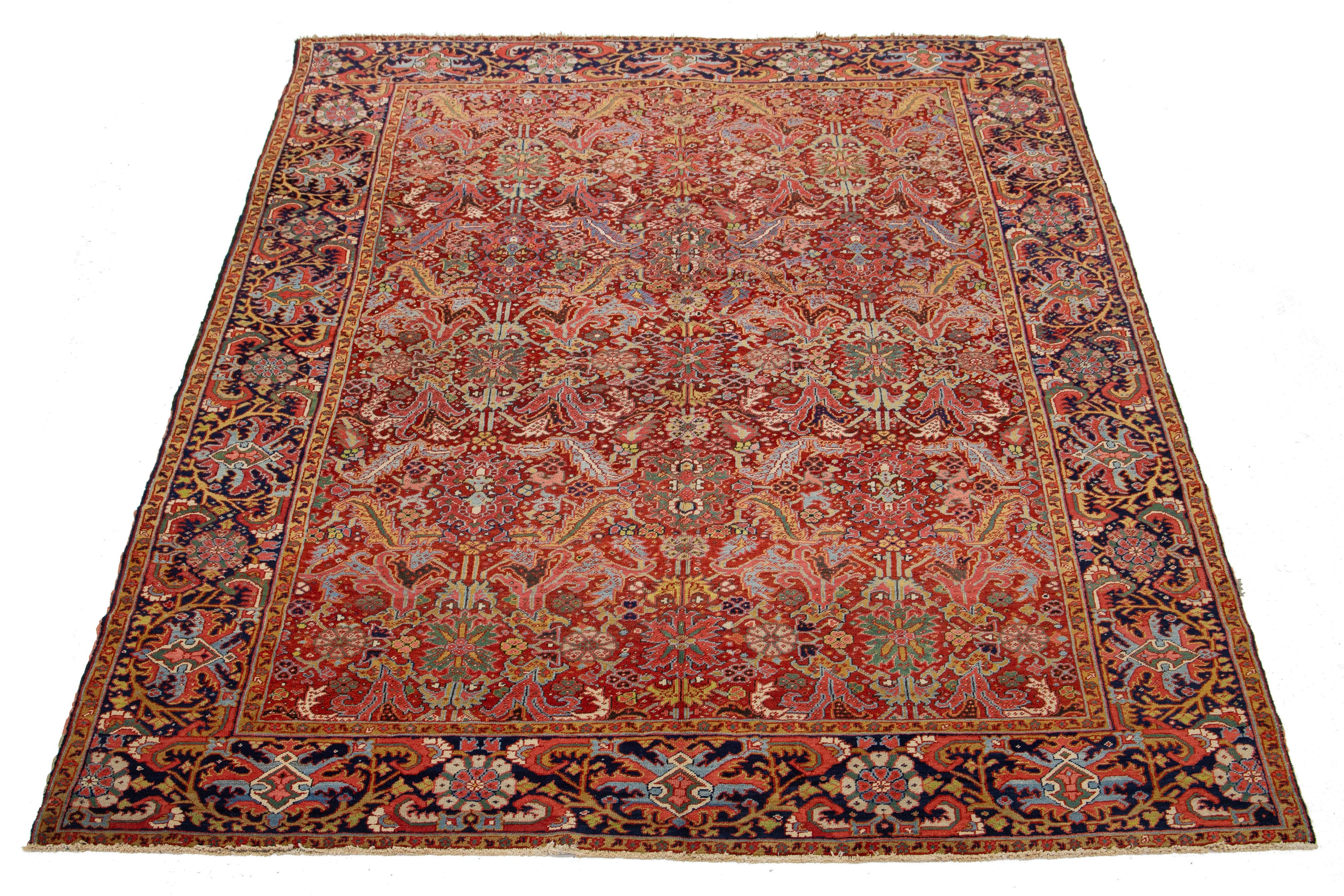 Ein antiker persischer Heriz-Wollteppich mit einem lebhaften mehrfarbigen Allover-Muster auf tiefrotem Hintergrund.

Dieser Teppich misst 9'5'' x 12'6''.

