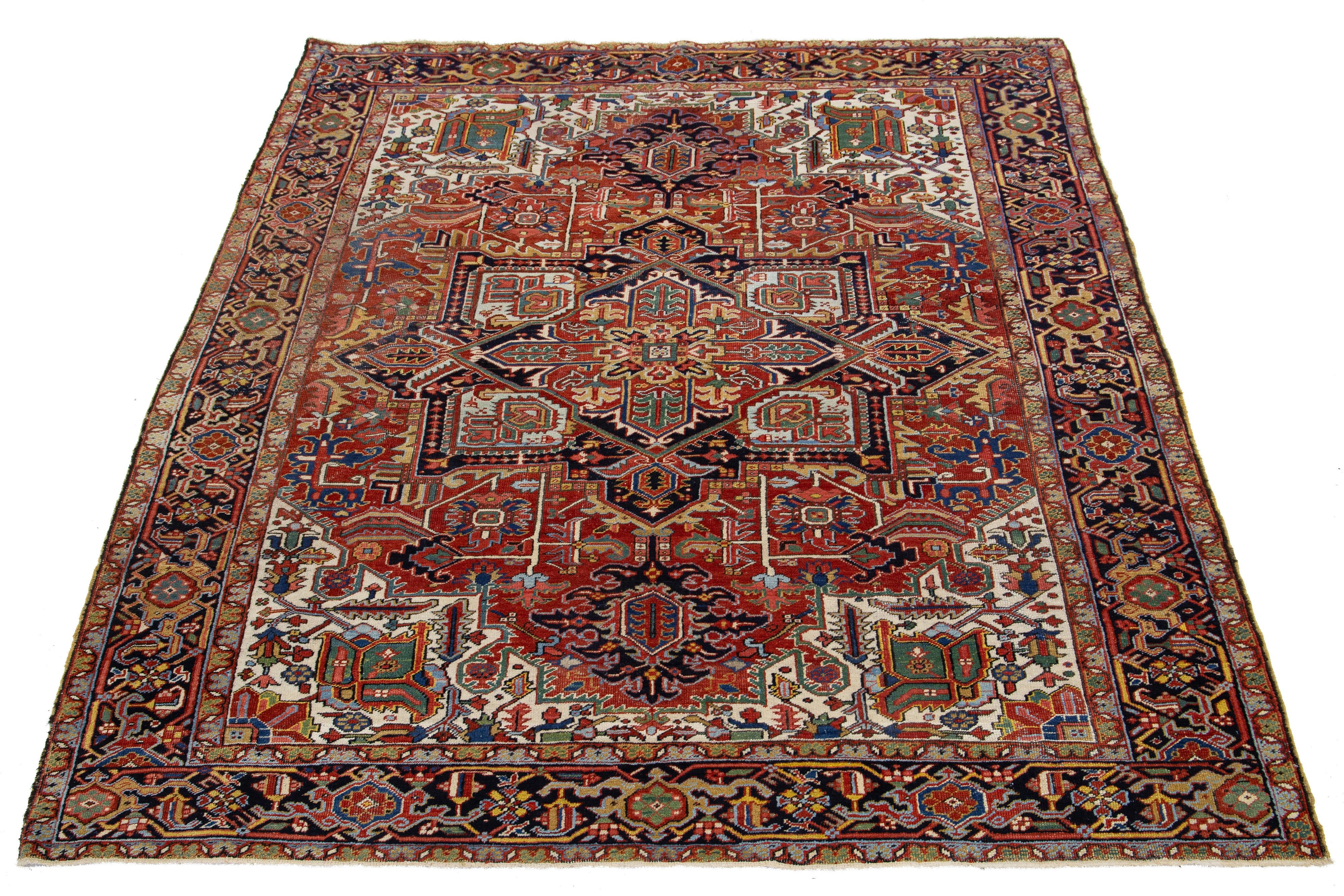 Un ancien tapis persan en laine Heriz présentant un motif multicolore vibrant sur un fond rouge profond.

Ce tapis mesure 7'8'' x 9'8''.

