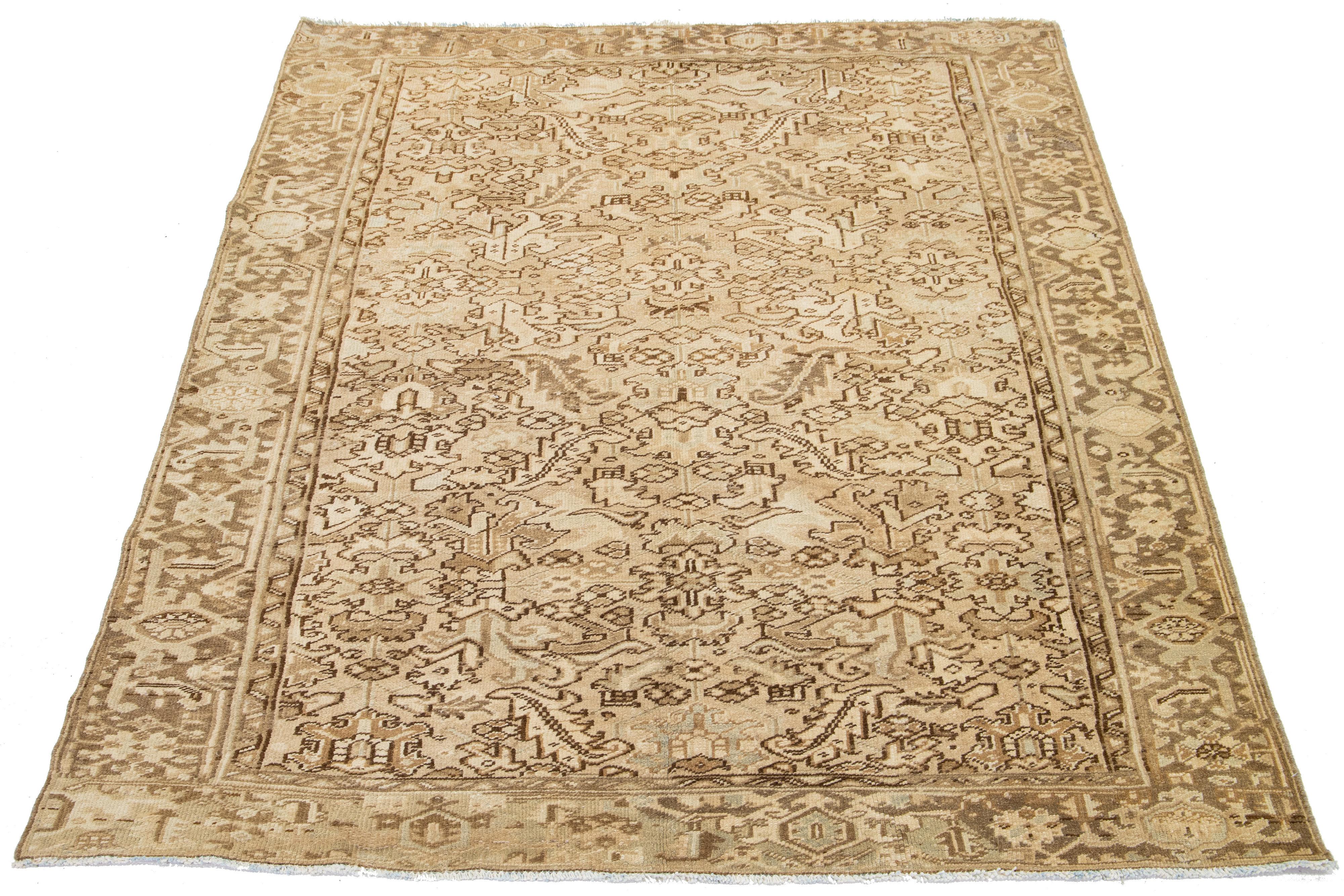 Questo antico tappeto persiano Heriz, annodato a mano, vanta un accattivante motivo allover nei toni del marrone su un campo beige.

Questo tappeto misura 6'11' x 9'3