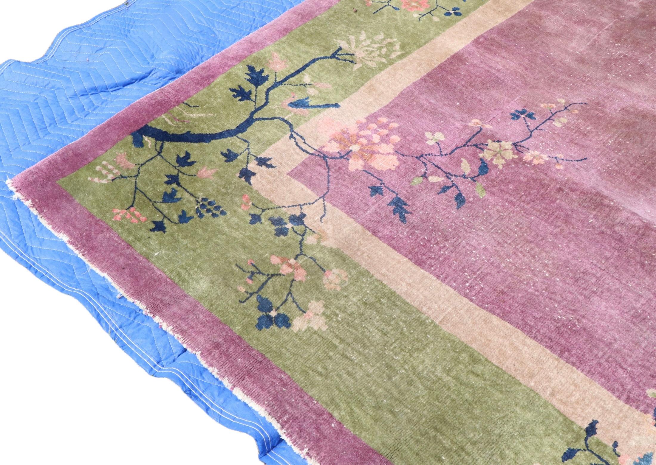 Classic Art Deco Chinese rug, attributed to Walter Nichols. The carpet features a purple field, with mustard, and green borders, and a restrained allover floral pattern. This example is free of odors, or significant condition issues, it does show