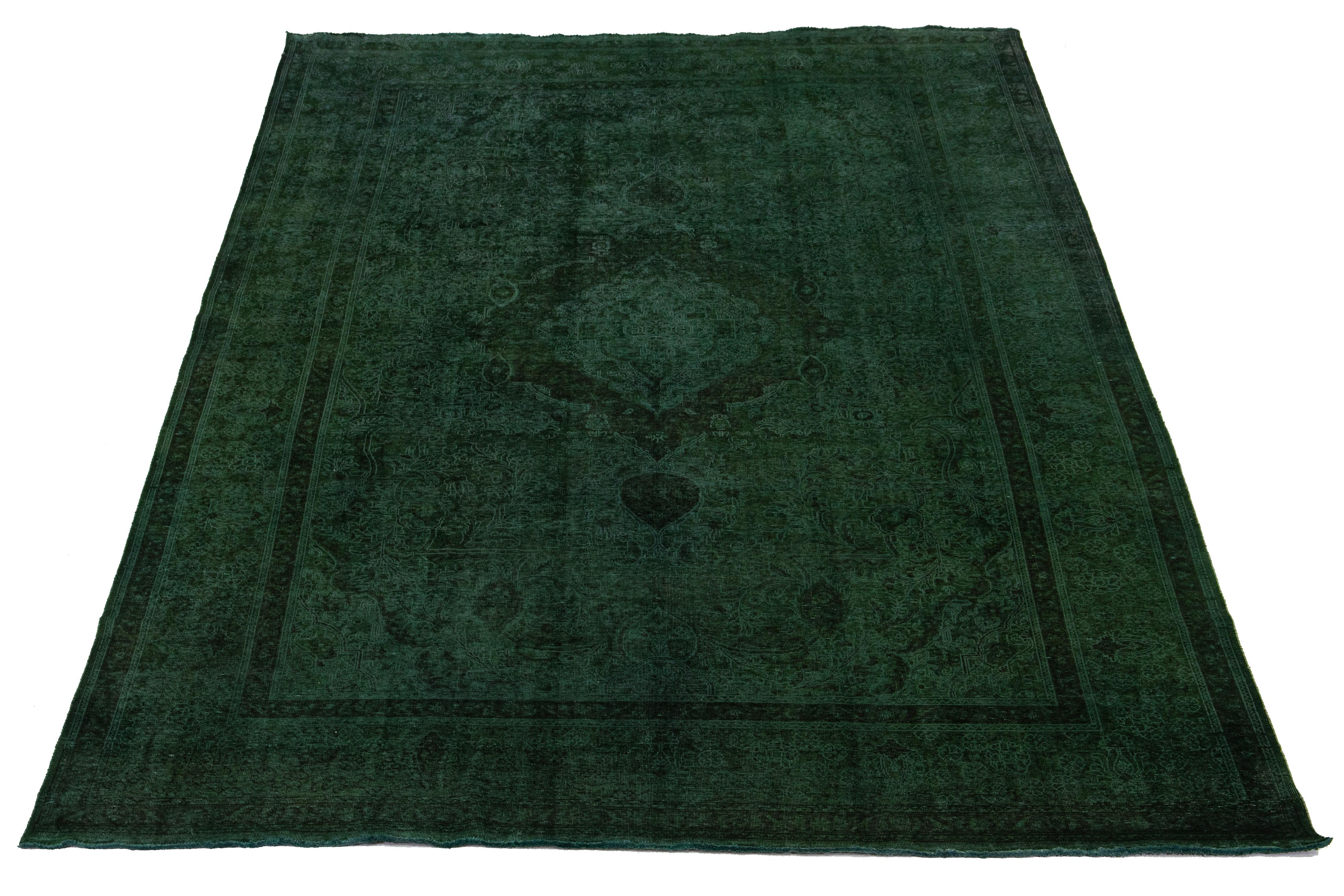 This is a vintage hand-knotted wool Persian rug with a green field. It features a medallion floral design with brown accents.

This rug measures 10'2'' x 15'9