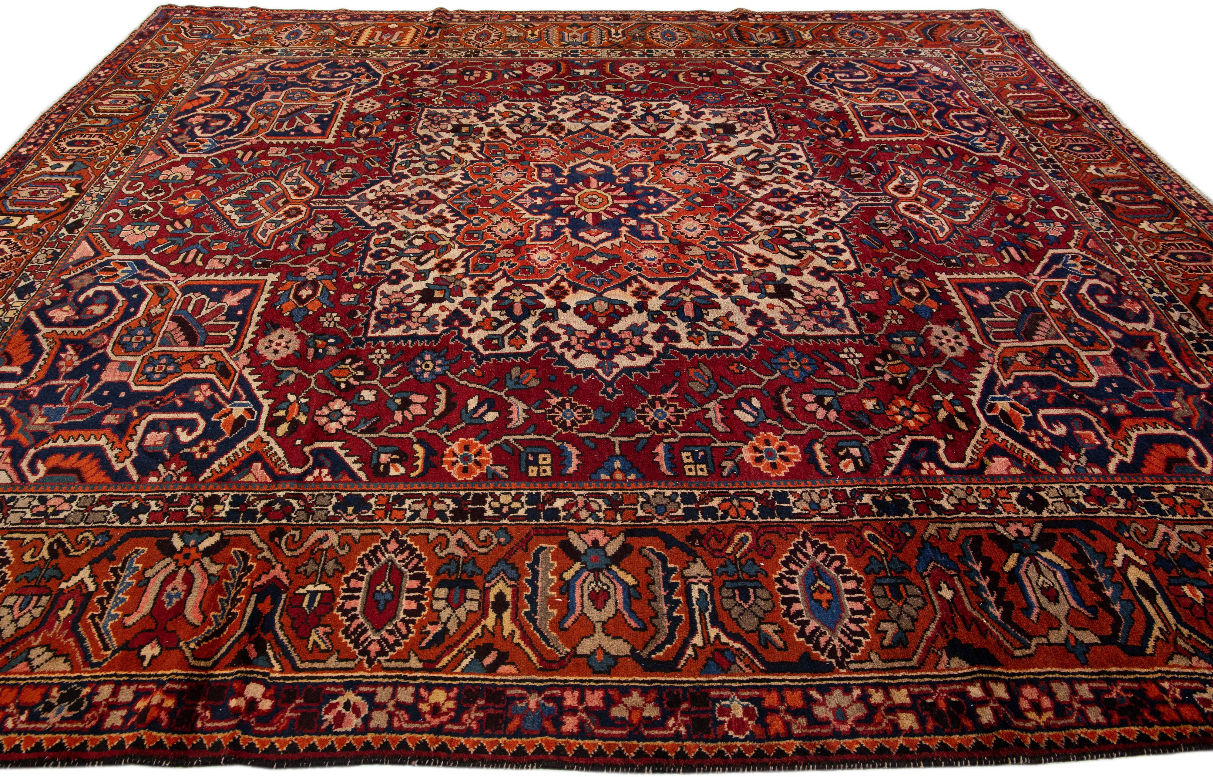Beautiful antique Bakhtiari hand-knotted wool rug with a red field. This Persian piece has an all-over multicolor accent in a gorgeous classic Medallion motif.

This rug measures 11'2