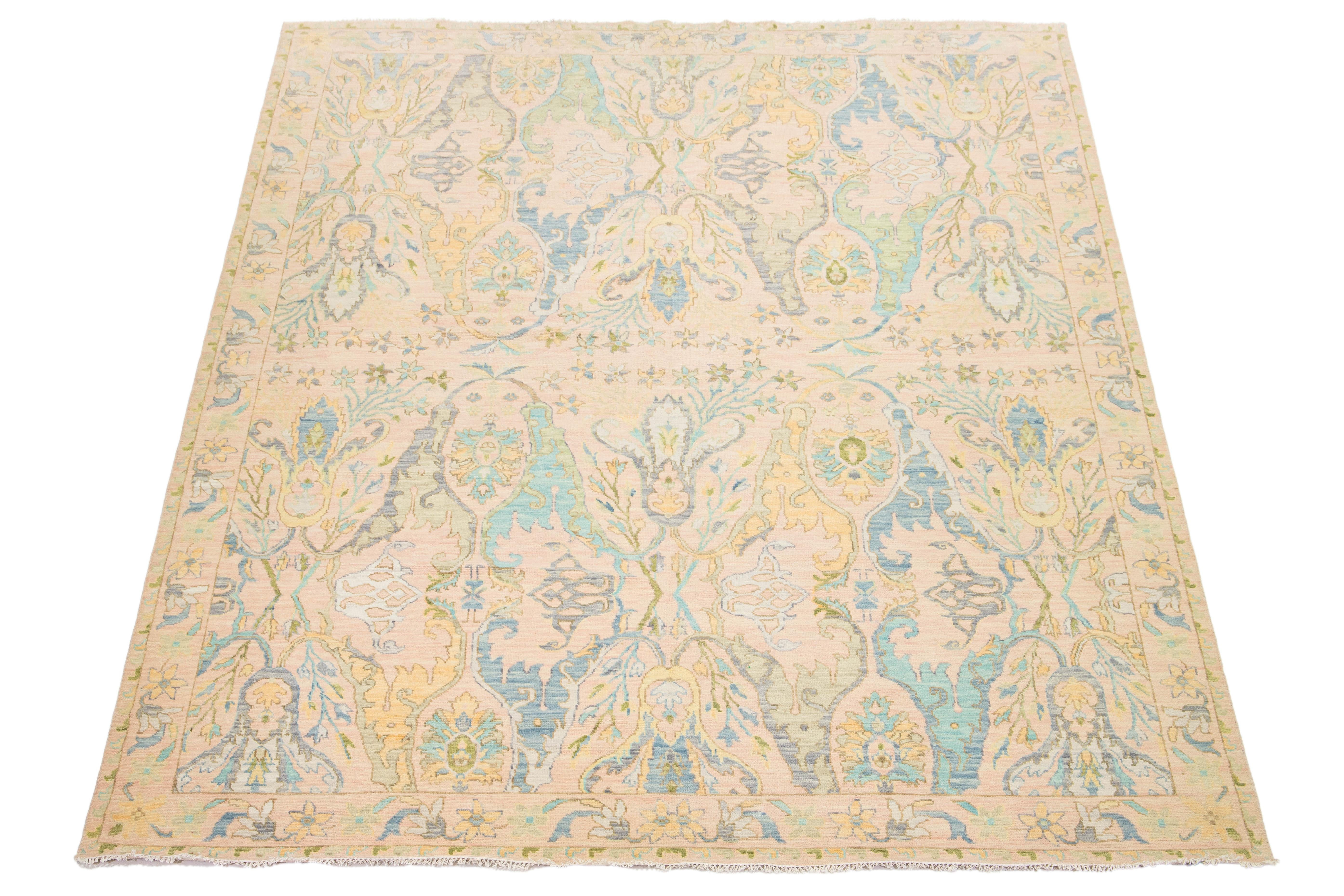 This contemporary Oushak-style wool rug seamlessly blends modern aesthetics with the enduring elegance of traditional Oushak craftsmanship. Its captivating peach background serves as a canvas for vibrant floral motifs, showcasing a dynamic palette