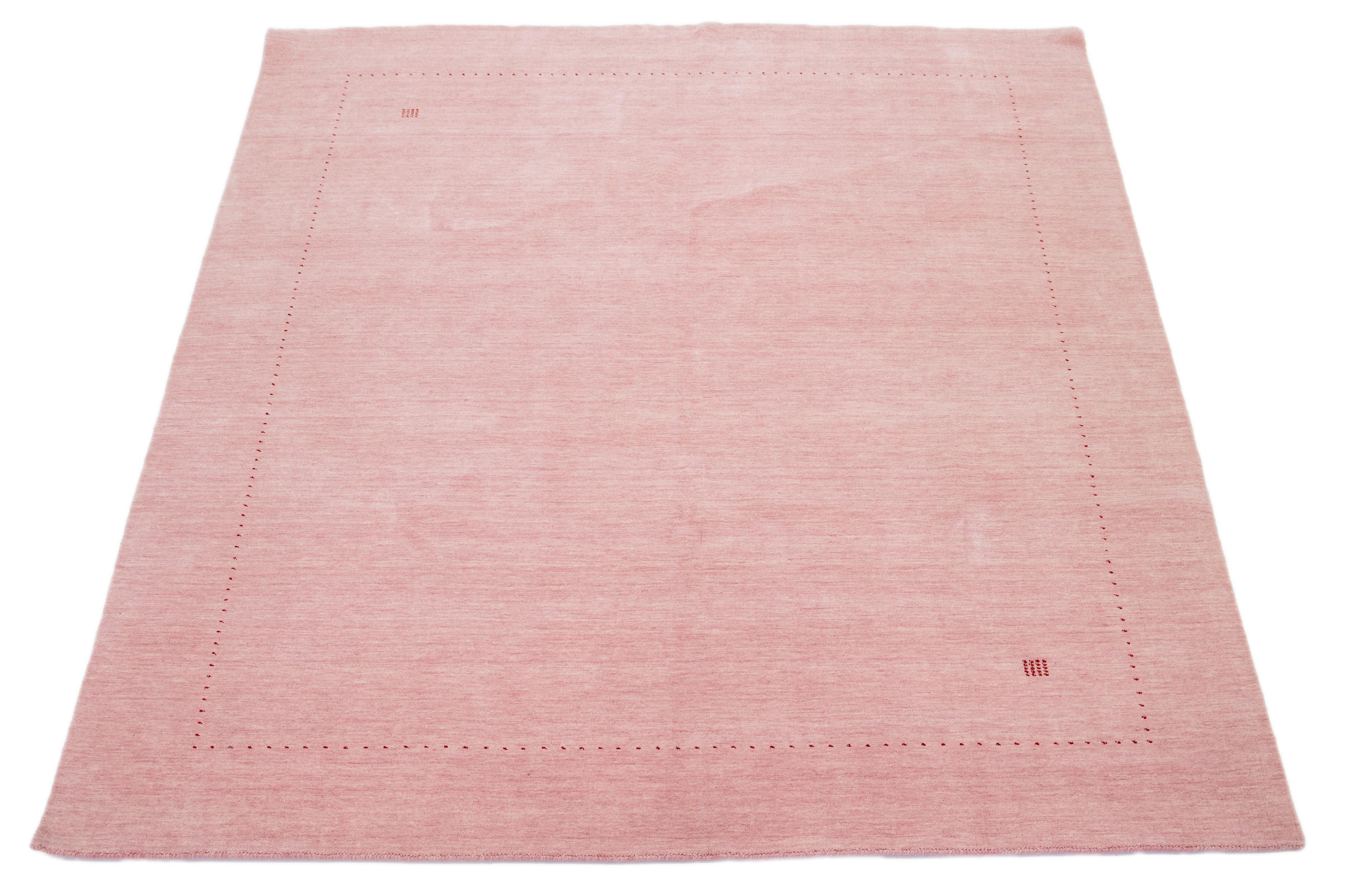 Dieser moderne Gabbeh-Teppich ist handgewebt und weist ein modernes, minimalistisches geometrisches Muster auf. Die rosafarbene Basis ist mit roten Details akzentuiert.

Dieser Teppich misst 8'3