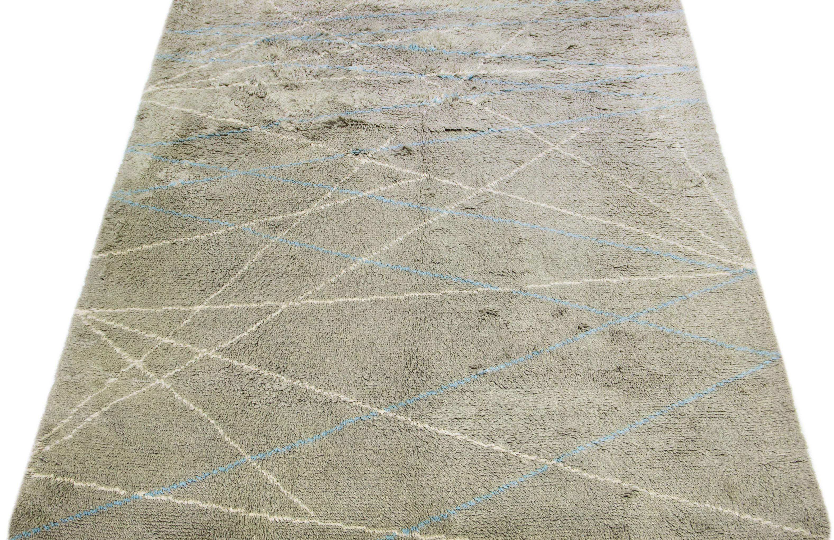 Hand-knotted with the finest wool, this Moroccan-inspired rug boasts a captivating tribal design on a gray base, accentuated with serene hues of blue and ivory.

This rug measures 9' x 12'.

Our rugs are professional cleaning before shipping.