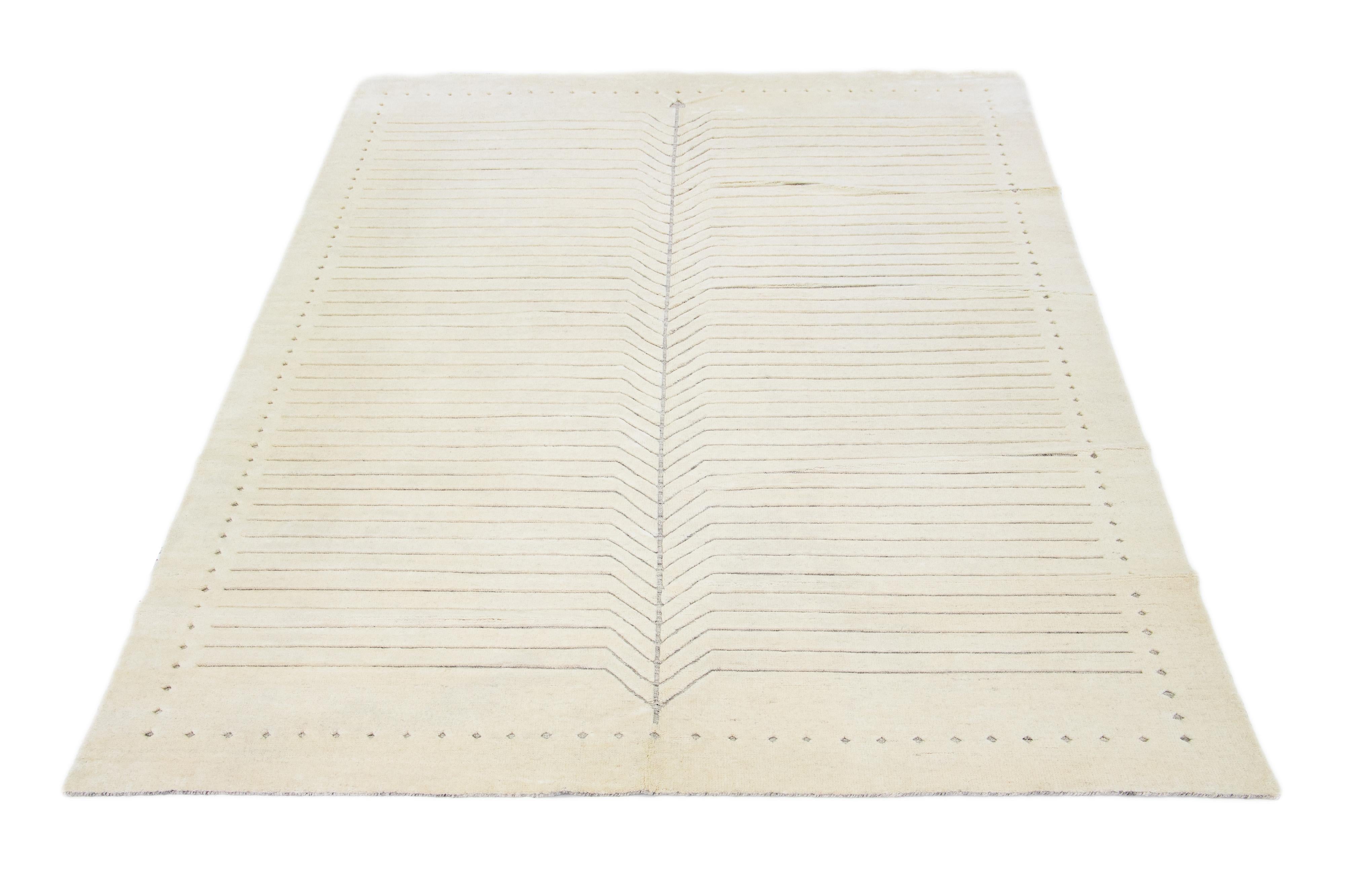 Exquisitely crafted by hand, this modern Moroccan rug features a luxuriously minimalist gray design in the most elegant ivories.

This rug measures 10' x 14'.