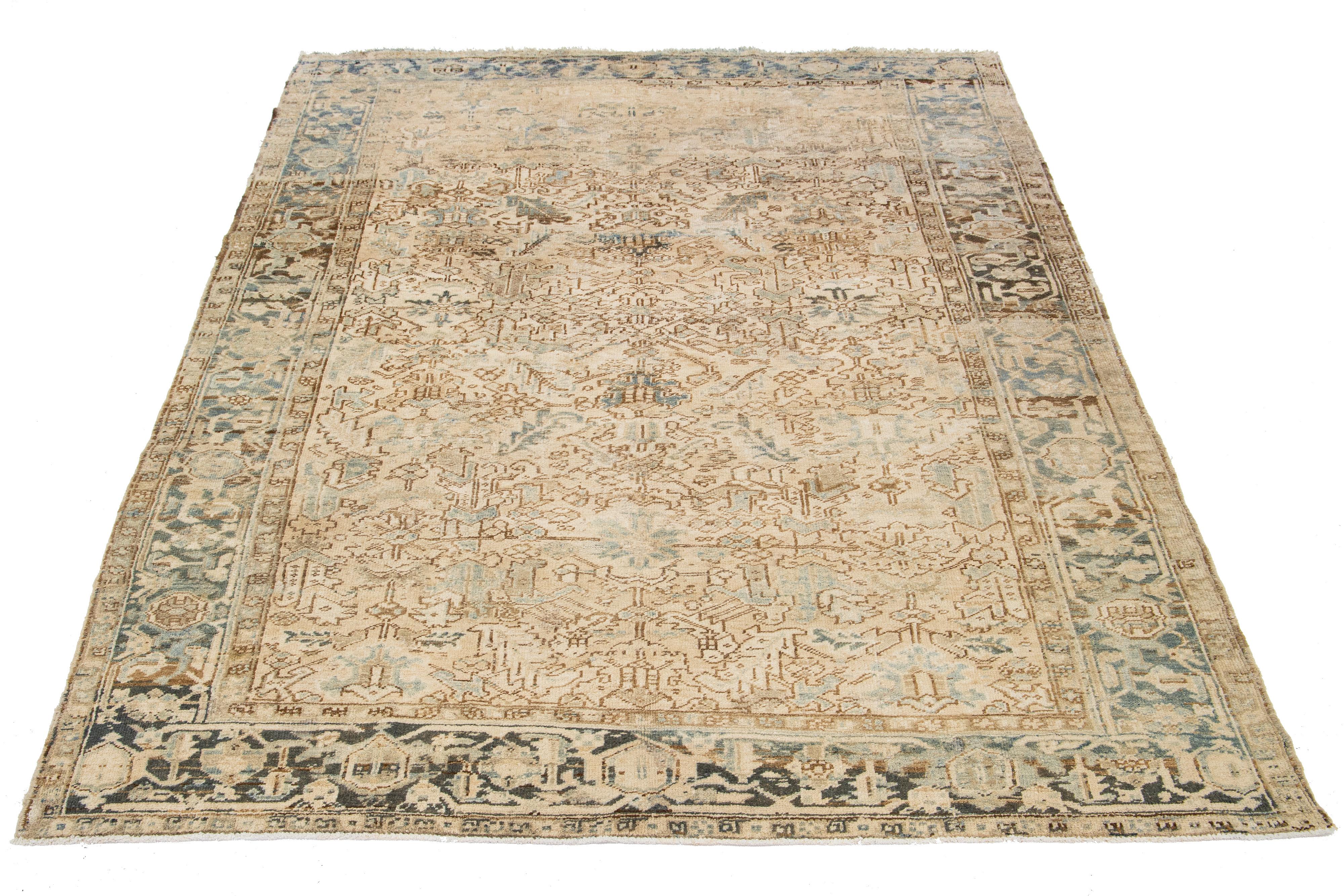 This antique Persian Heriz rug is crafted from hand-knotted wool. It features a captivating allover pattern in shades of blue and light brown on a beige field.

This rug measures 7'8' x 11'1