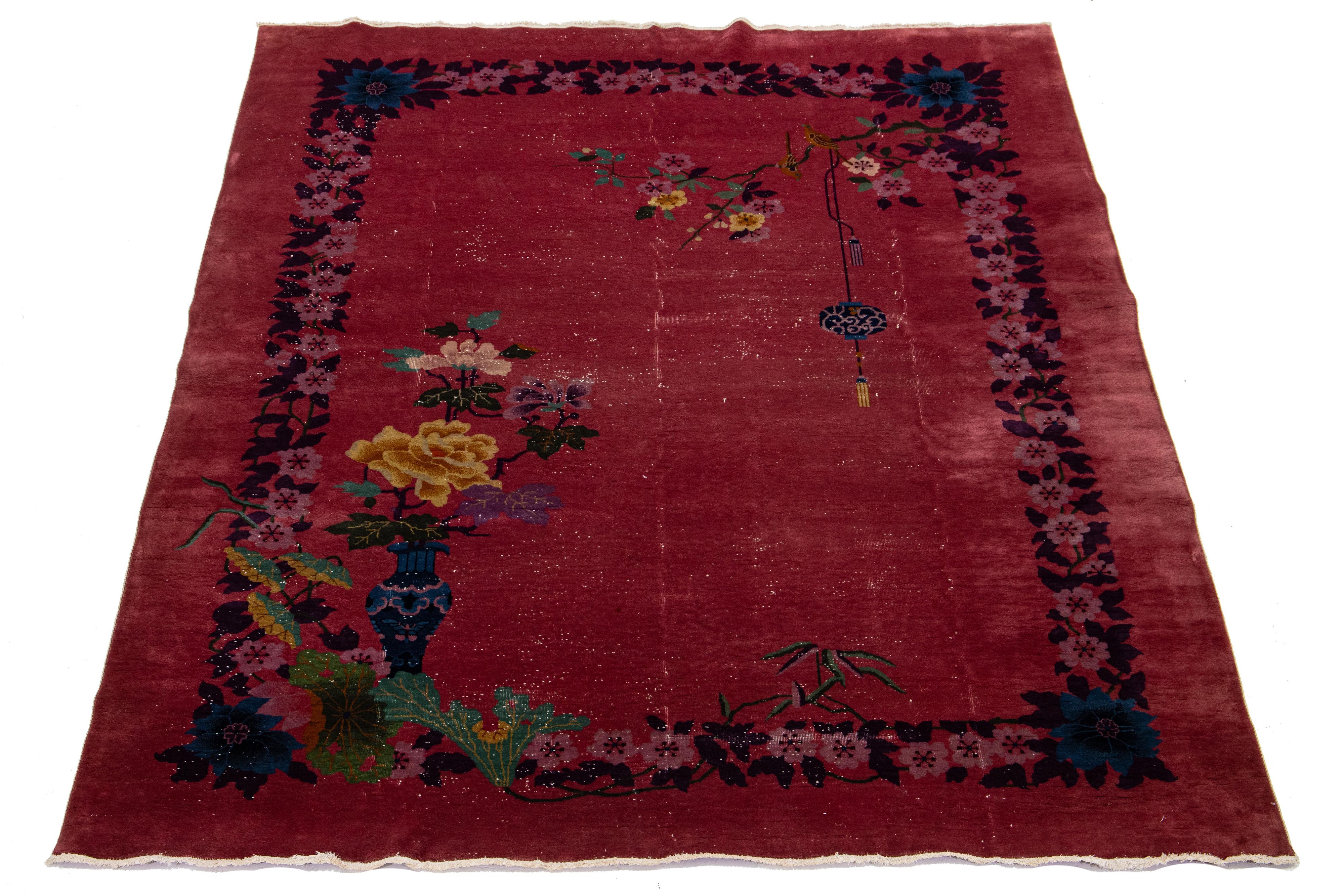 Dies ist ein antiker chinesischer Art-Deco-Teppich! Er ist aus Wolle handgeknüpft und zeichnet sich durch ein kräftiges rotes Feld und auffällige mehrfarbige Farbtöne aus. Der Teppich ist mit einem klassischen chinesischen Blumenmuster