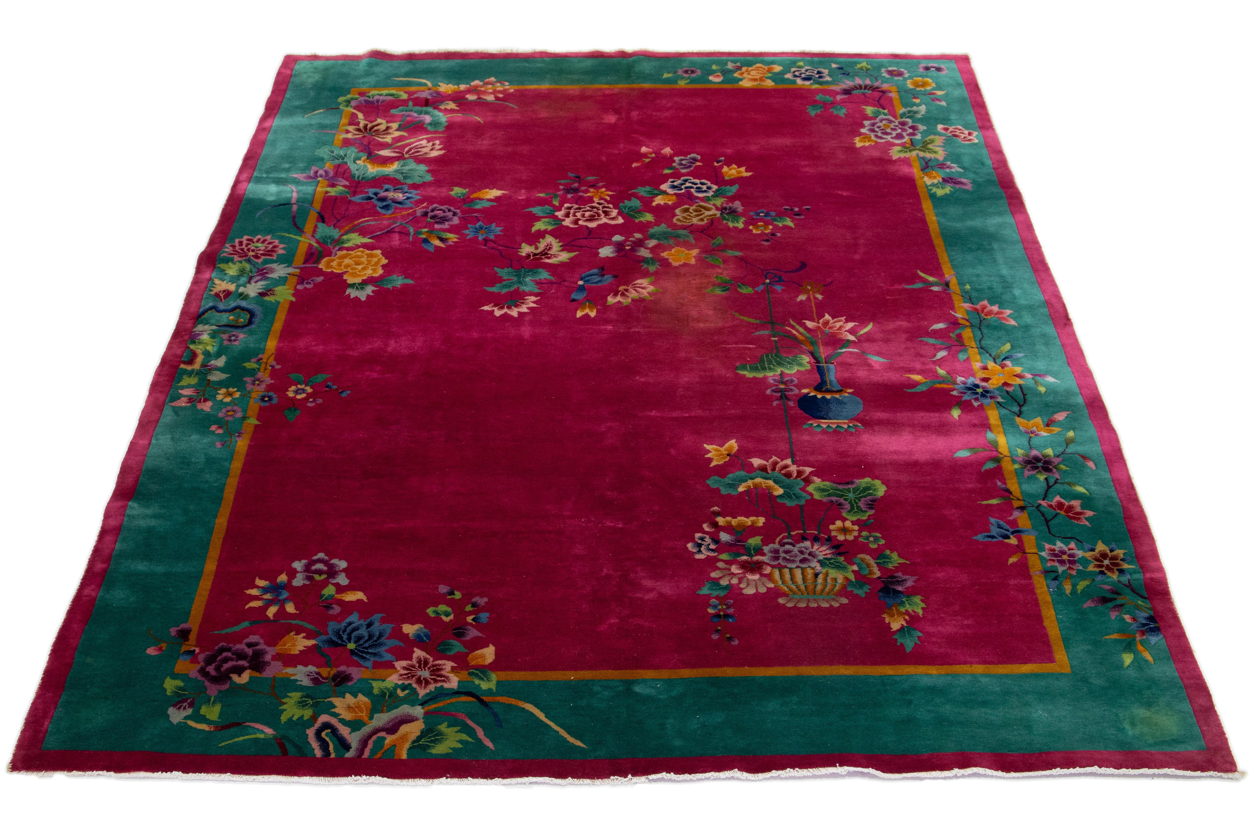 Dieser handgeknüpfte Wollteppich im antiken chinesischen Art-Déco-Stil hat einen himbeerroten Hintergrund. Es zeigt ein florales Design in mehrfarbigen Tönen mit grünem Rahmen.


Dieser Teppich misst 8'8