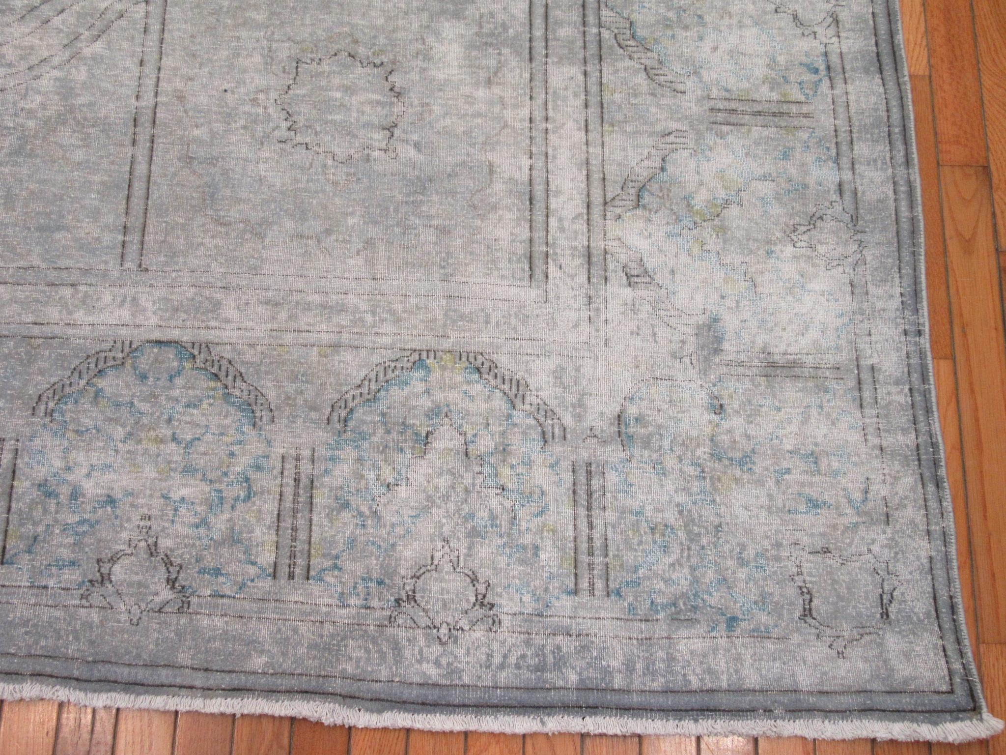 This is an room size vintage distressed hand knotted Persian Kirman rug. It is made with wool on cotton foundation lightly overdyed in gray color background. It has a traditional open field design with a large medallion.
The rug measures 9' 5” x