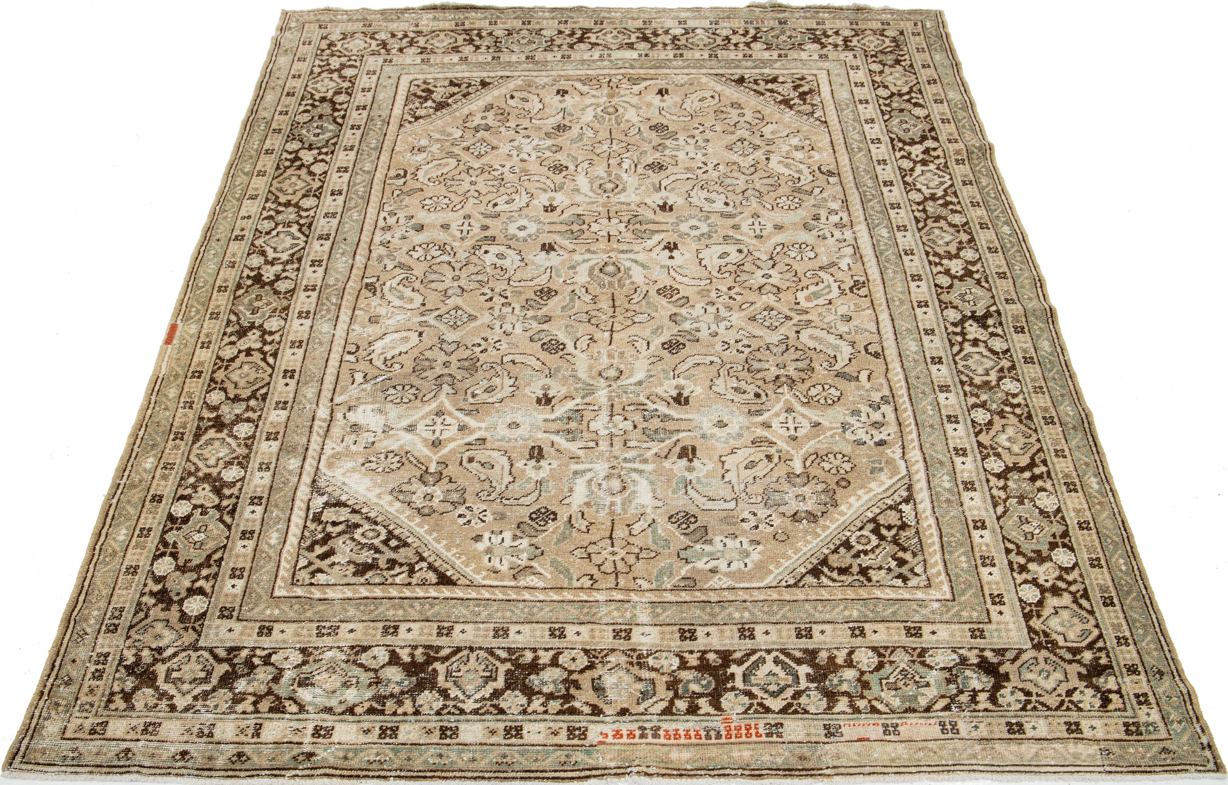 This Vintage Persian Mahal wool rug has a beige background and blue, rust, and brown floral designs.

This rug measures 7'5