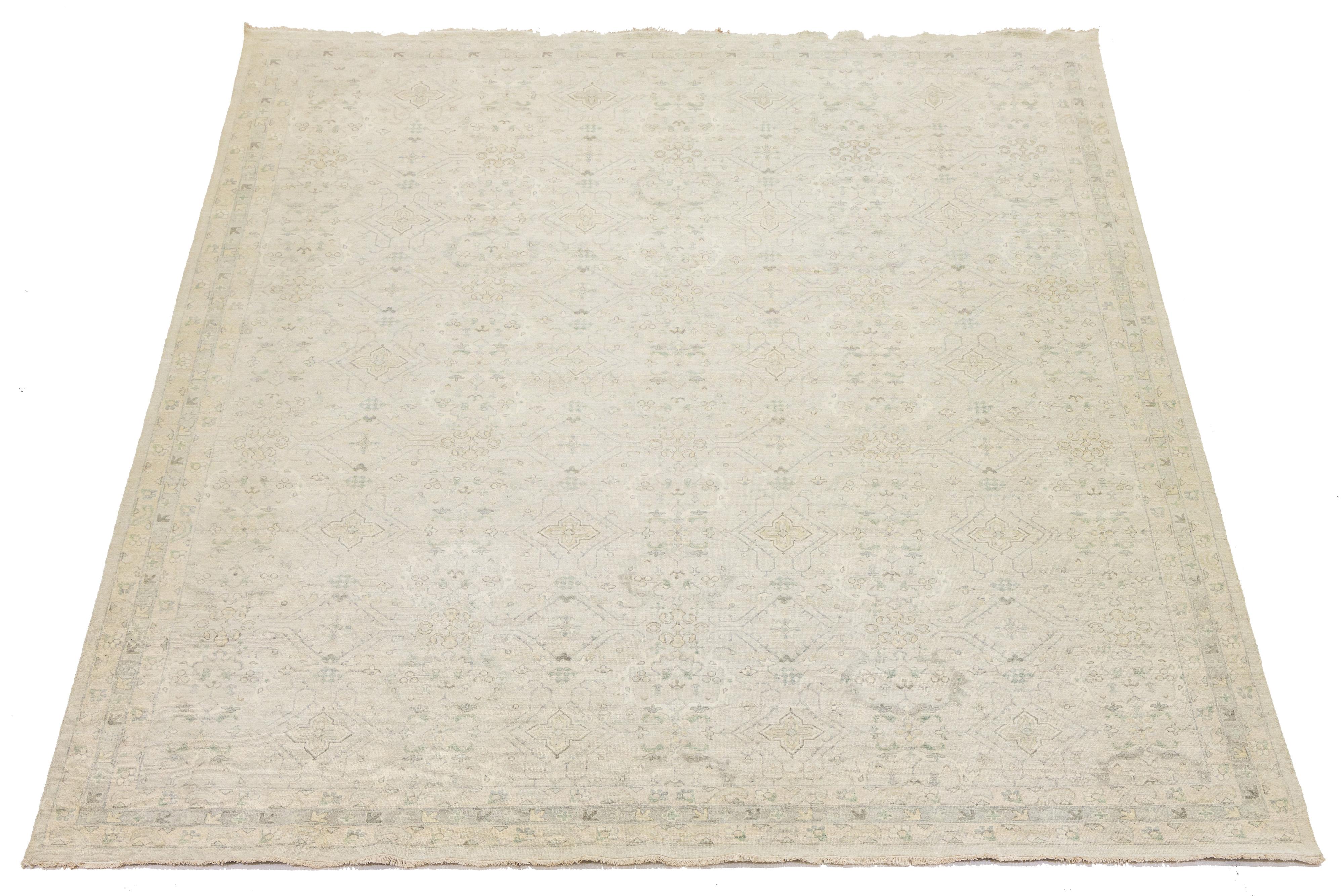 Ce tapis contemporain en laine de style Oushak allie avec brio l'esthétique moderne au charme durable de l'artisanat traditionnel Oushak. Il est orné d'une superbe toile de fond beige clair, agrémentée de motifs floraux complexes qui affichent une