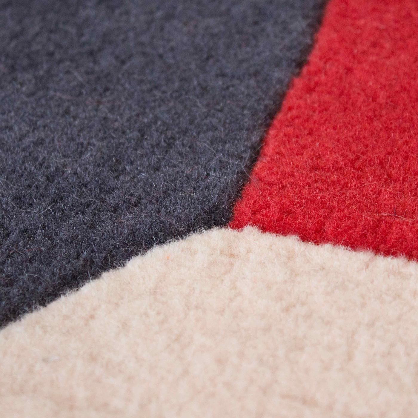 En un sorprendente juego de colores, las formas geométricas crean una ilusión óptica tridimensional en la superficie de esta espléndida alfombra diseñada por Serena Confalonieri. Esta elegante pieza, ideal para interiores modernos, está totalmente